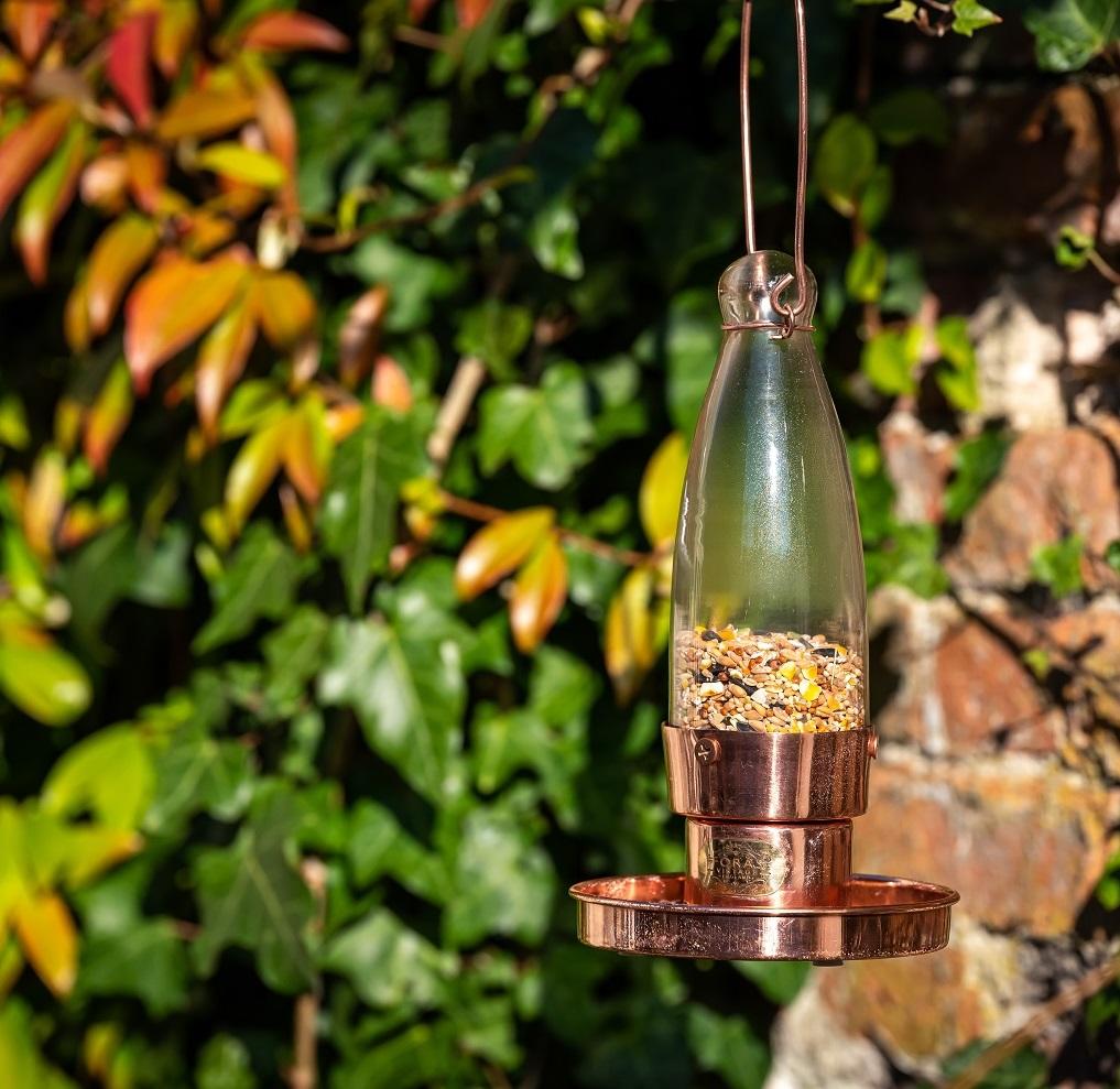 copper garden bird feeder with hand blown glass