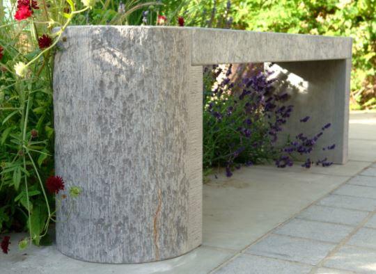 grey stone modern garden bench in curved shape