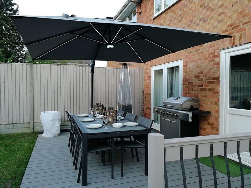 garden cantilevered parasol in smoke grey over patio dining set