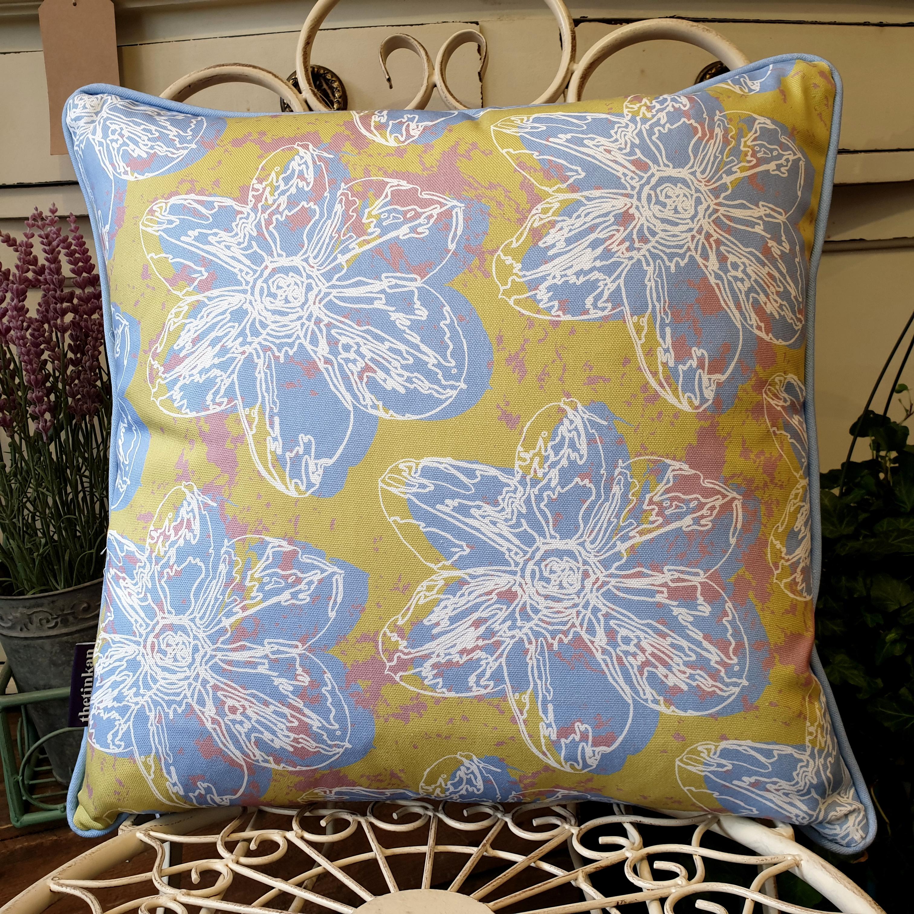 Double-sided 45cm square Flower Splash cushion designed by thetinkan. Pale blue narcissus flower and pale blue piping with white traced outline set within a light olive green background with salmon pink paint splashes. Available with an optional luxury cushion inner pad. VIEW PRODUCT >>