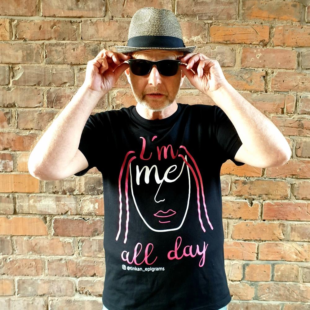 Adult male wearing black t-shirt with white handdrawn face with pink hair with the words I'm Me All Day printed. Designed by thetinkan. VIEW PRODUCT >>