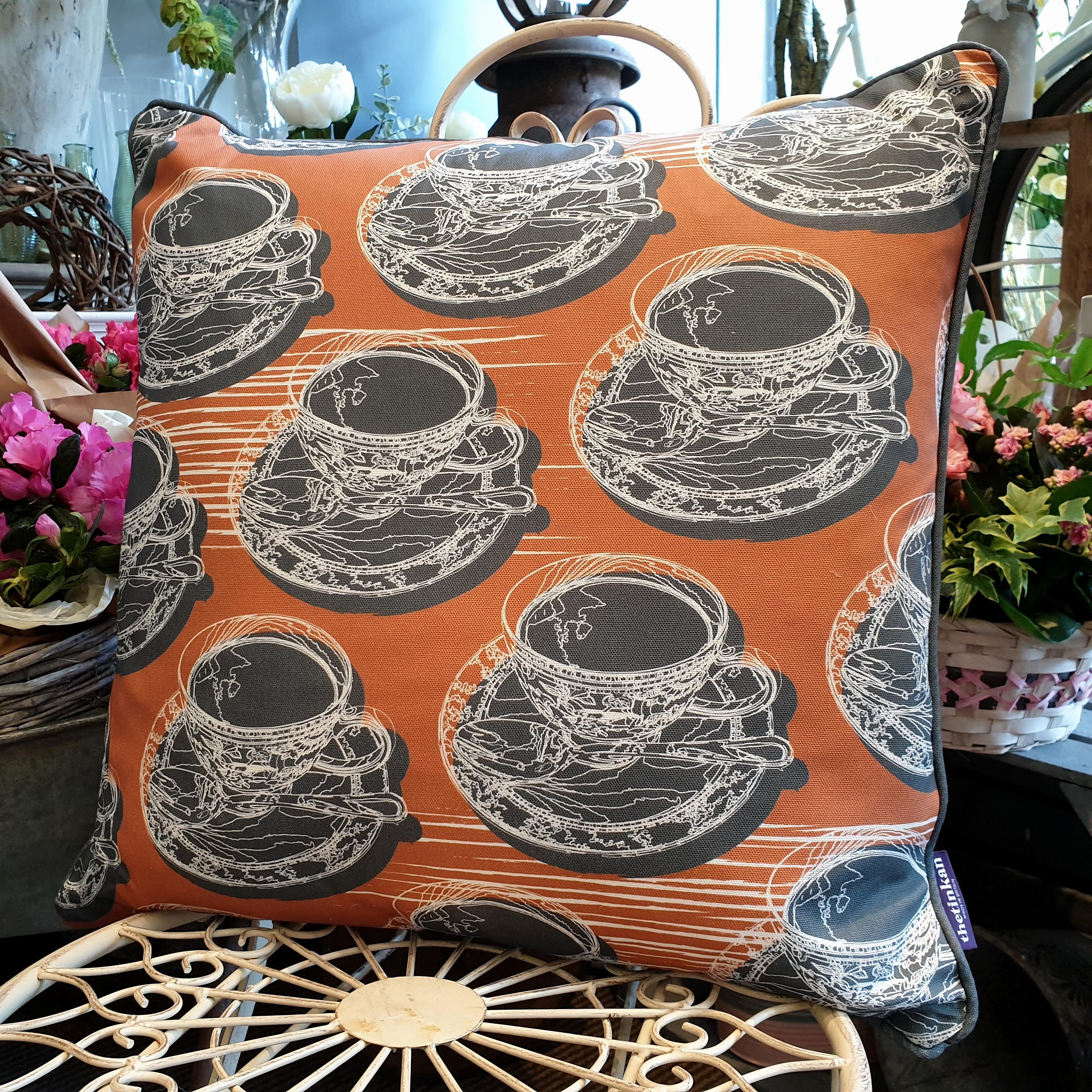 Double-sided warm rust orange 51cm square retro Afternoon Tea cushion with artistic white shards and grey handcrafted piping designed by thetinkan. White traced outline of multiple British teacups and saucers each colour filled in charcoal grey. Available with an optional luxury cushion inner pad. VIEW PRODUCT >>