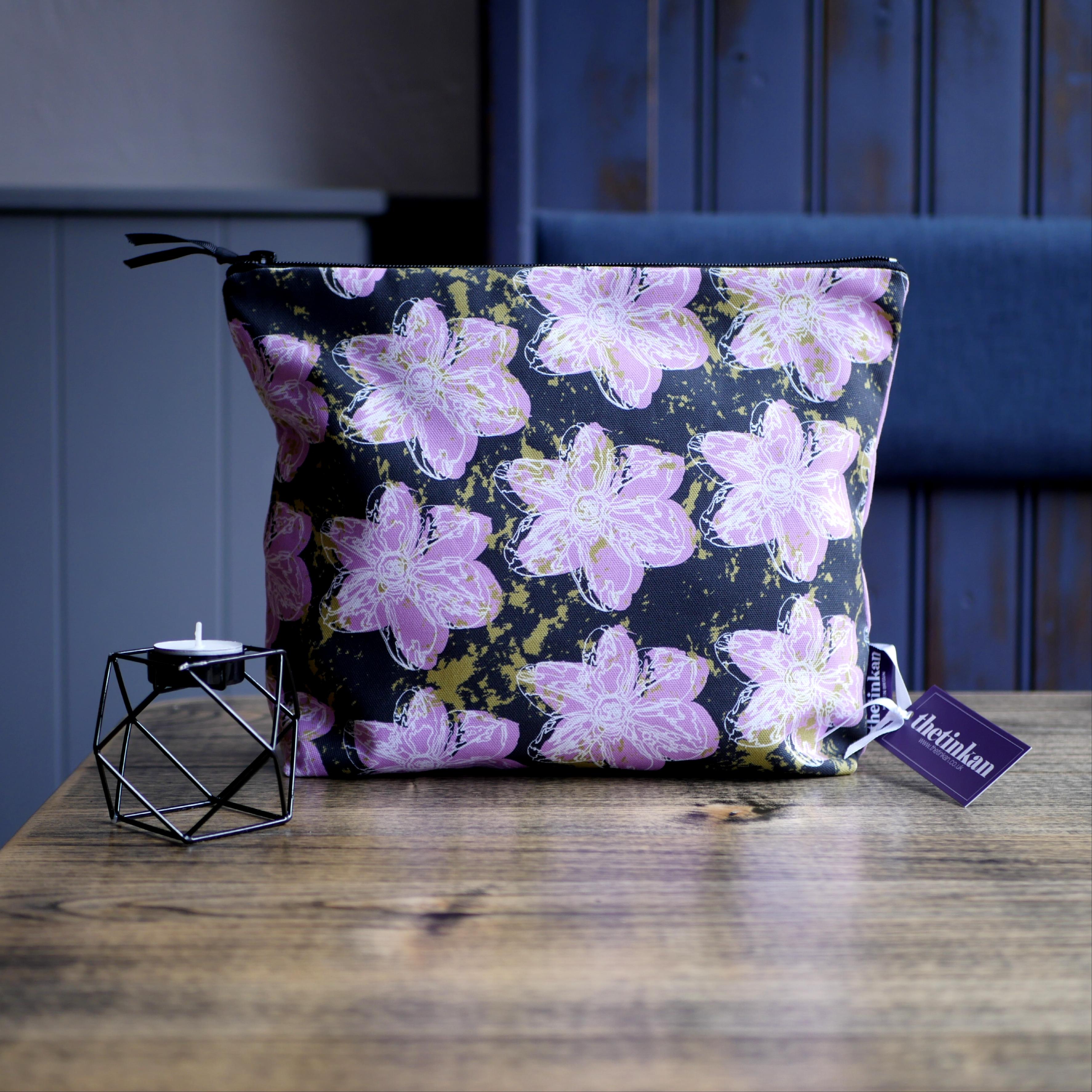 Candy pink flower with a matching coloured reverse, set on a dark charcoal grey background with an olive green colour splash. Designed by thetinkan, the flower splash travel beauty washbag featuring the white traced outline of a narcissus flower is made from panama cotton with black waterproof lining and matching black sturdy zip. Generously sized for all your travel or home needs.  VIEW PRODUCT >>