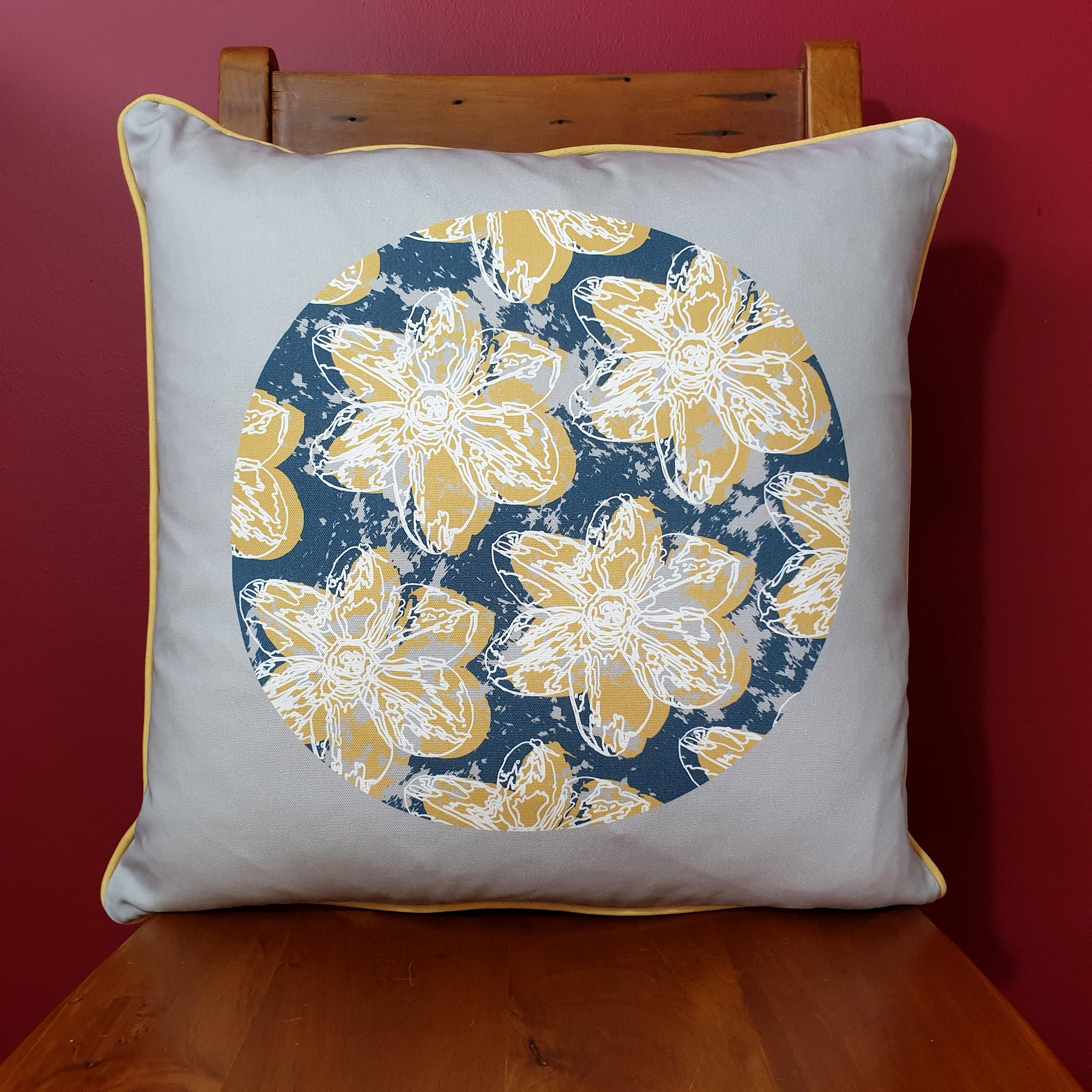 Double-sided 51cm square Flower Splash cushion designed by thetinkan. Mustard yellow narcissus flower with white traced outline and mustard yellow piping set in an oxford blue coloured circle with pale grey paint splashes and pale grey surround. Available with an optional luxury cushion inner pad. VIEW PRODUCT >>