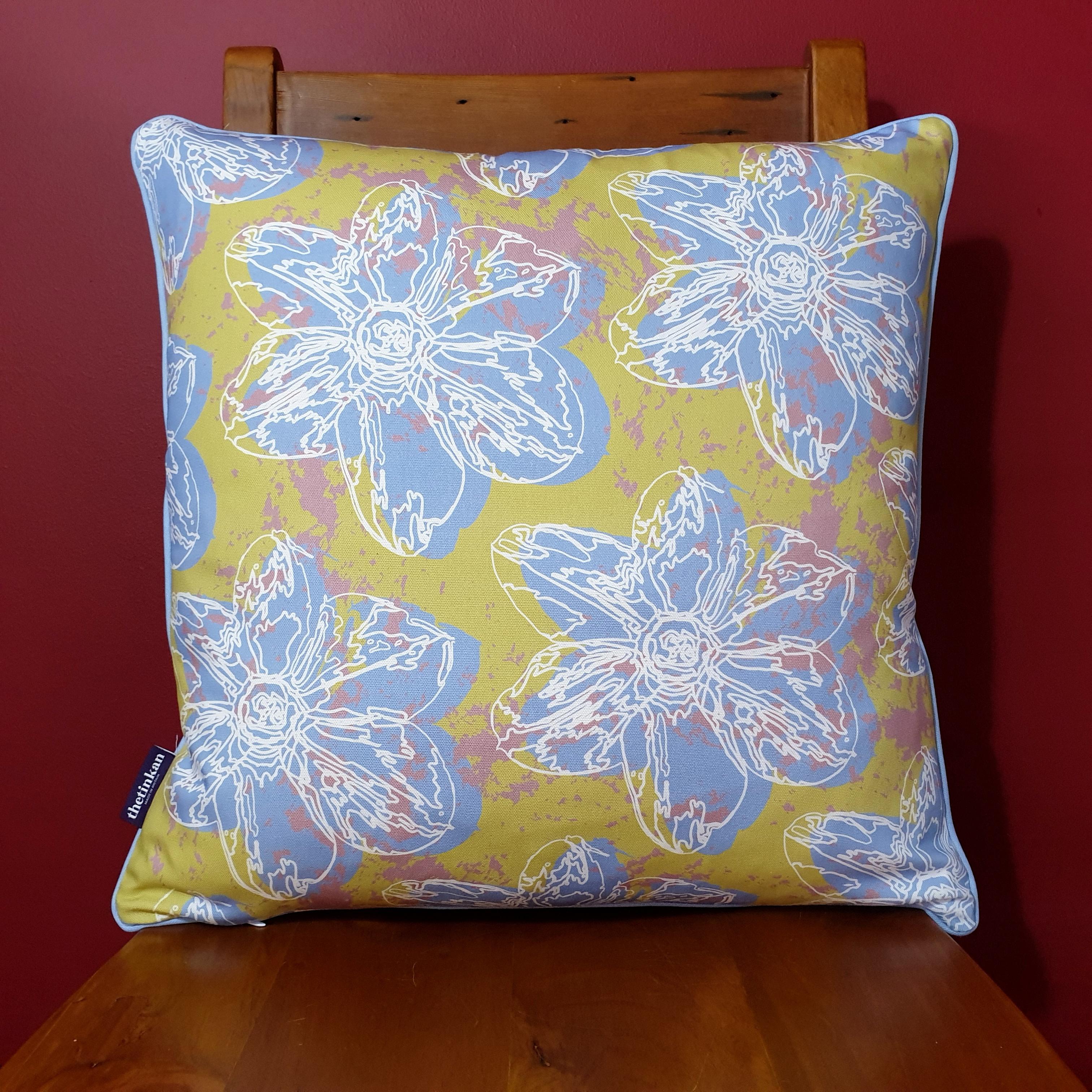 Double-sided 51cm square Flower Splash cushion designed by thetinkan. Pale blue narcissus flower and pale blue piping with white traced outline set within a light olive green background with salmon pink paint splashes. Available with an optional luxury cushion inner pad. VIEW PRODUCT >>