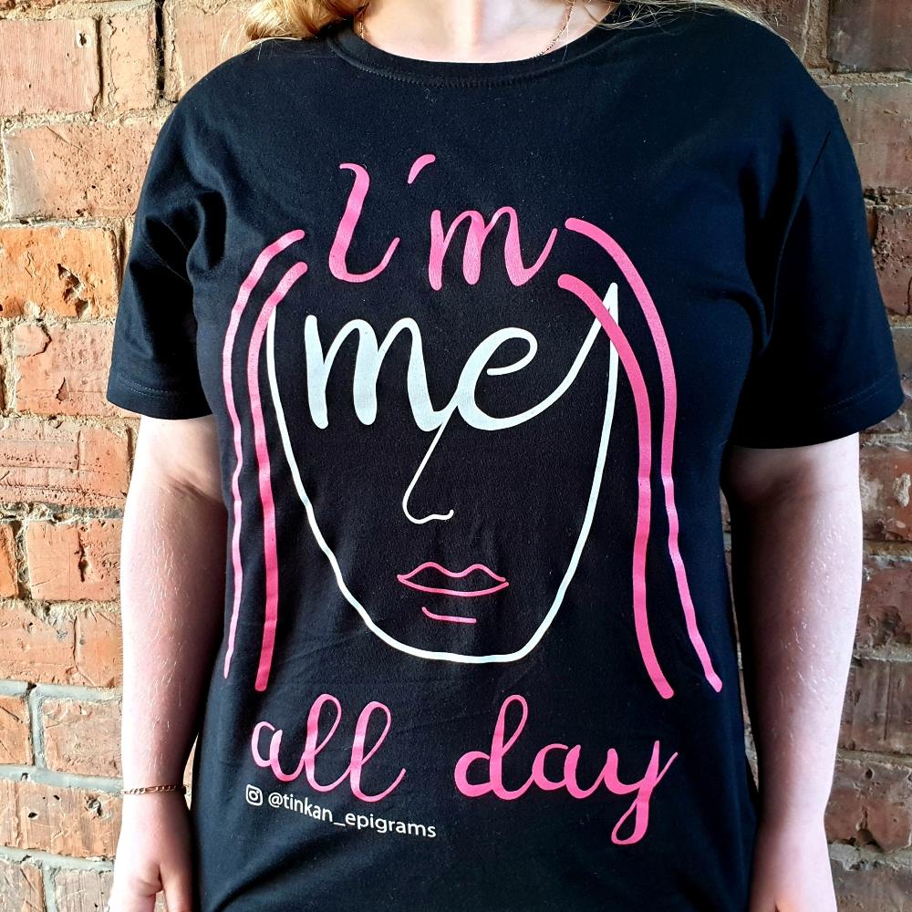 Adult female wearing black t-shirt with white handdrawn face with pink hair with the words I'm Me All Day printed. Designed by thetinkan. VIEW PRODUCT >>