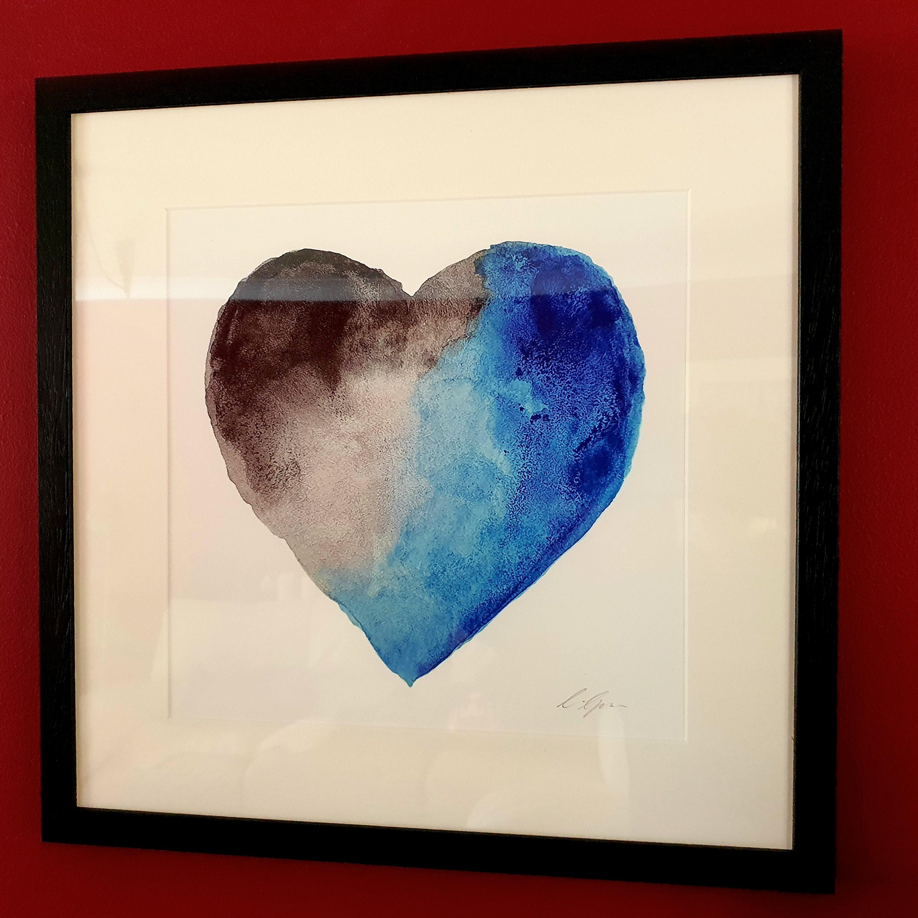 A watercolour print by Clarrie-Anne on eco fine art paper titled Thunder Heart showing a blue and greyscale watercolour heart on a white background.