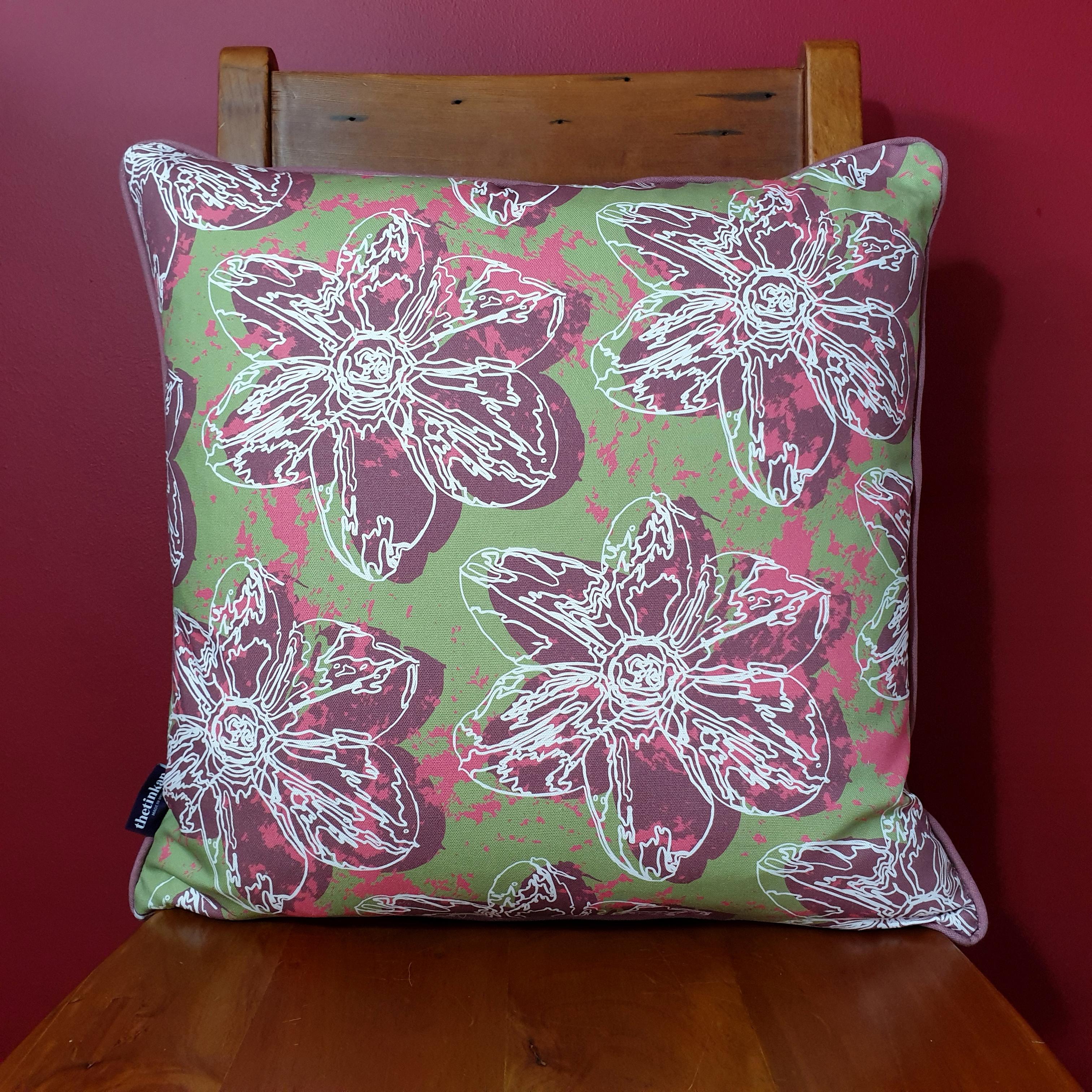 Double-sided 51cm square Flower Splash cushion designed by thetinkan. Dark red narcissus flower and dark red piping with white traced outline set within an olive green background with salmon pink paint splashes. Available with an optional luxury cushion inner pad. VIEW PRODUCT >>
