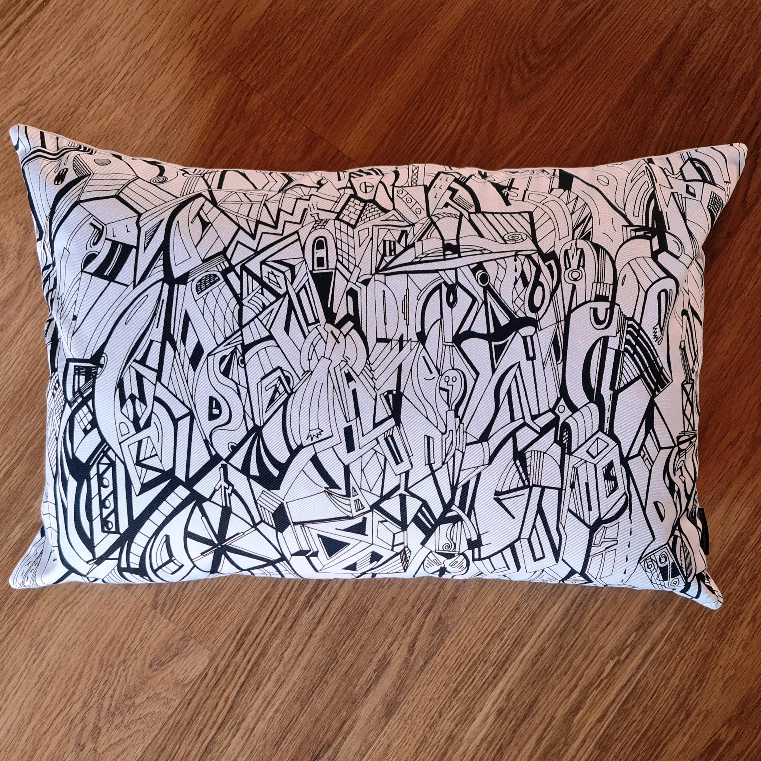 Cream coloured cotton rectangular cushion with artwork from Jason Clarke printed on the front.