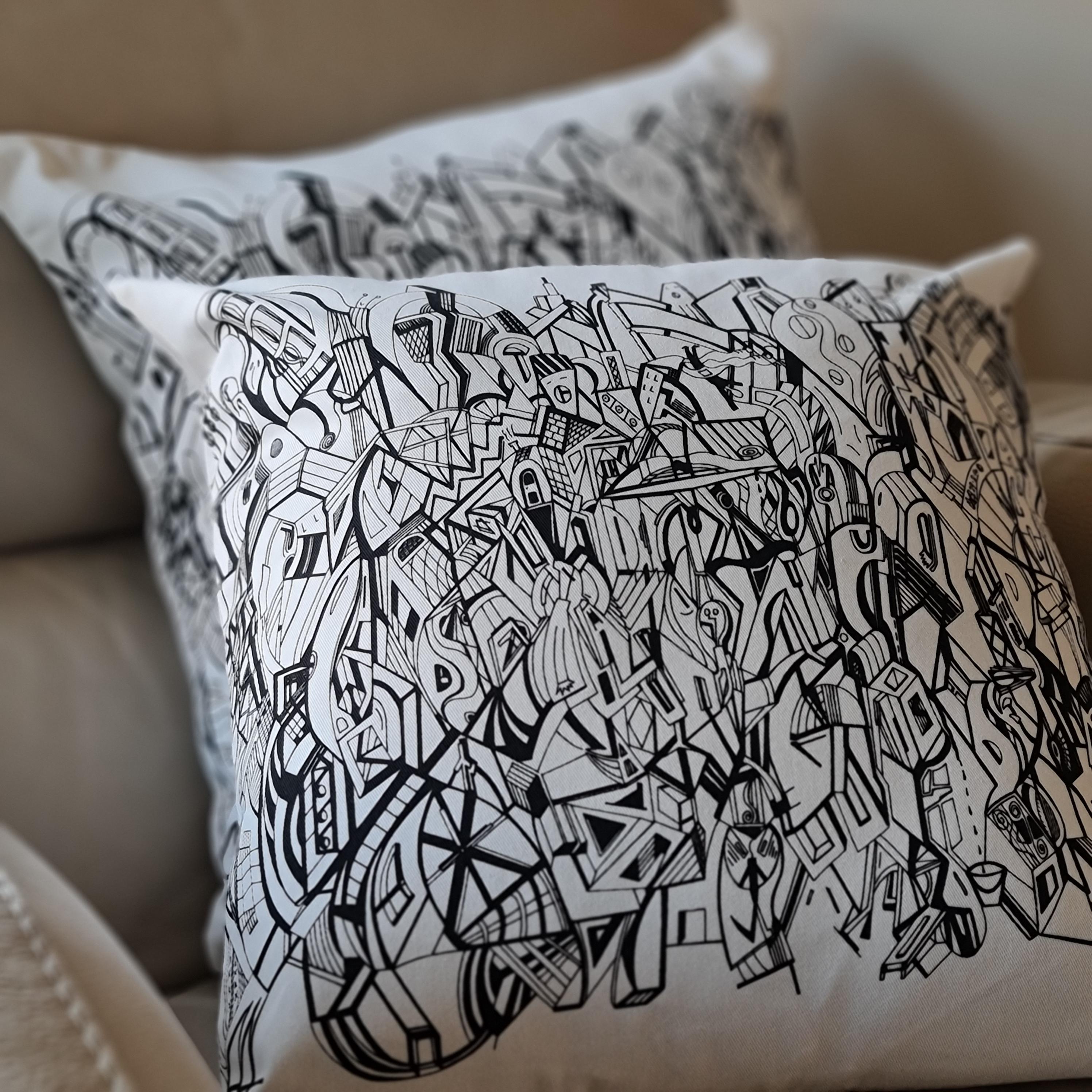 A cream coloured square cushion with the black artwork of Jason Clarke printed on the front
