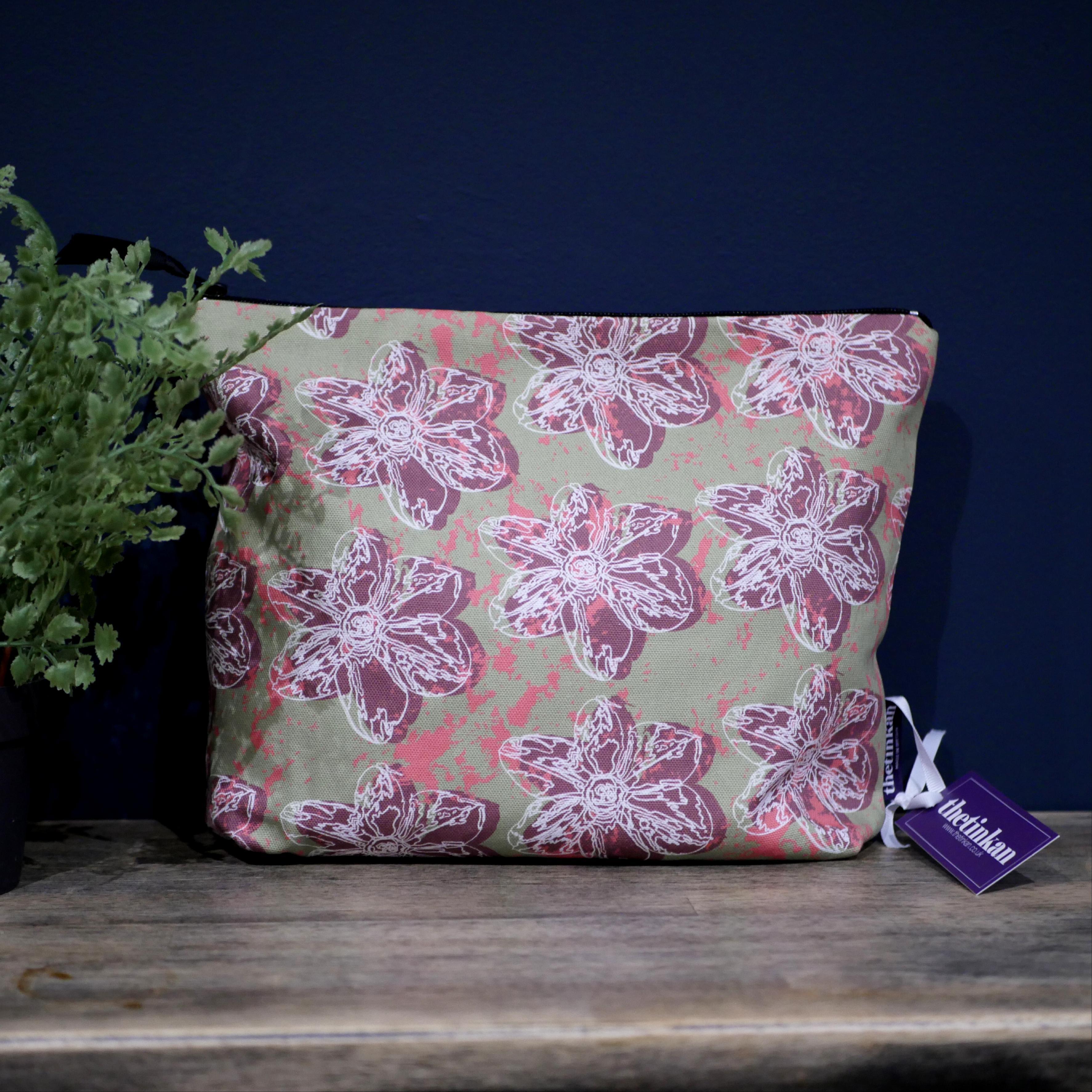 Dark red flower with a matching coloured reverse, set on an olive green background with a salmon pink colour splash. Designed by thetinkan, the flower splash travel beauty washbag featuring the white traced outline of a?narcissus flower is made from panama cotton with black waterproof lining and matching black sturdy zip. Generously sized for all your travel or home needs.? VIEW PRODUCT >>