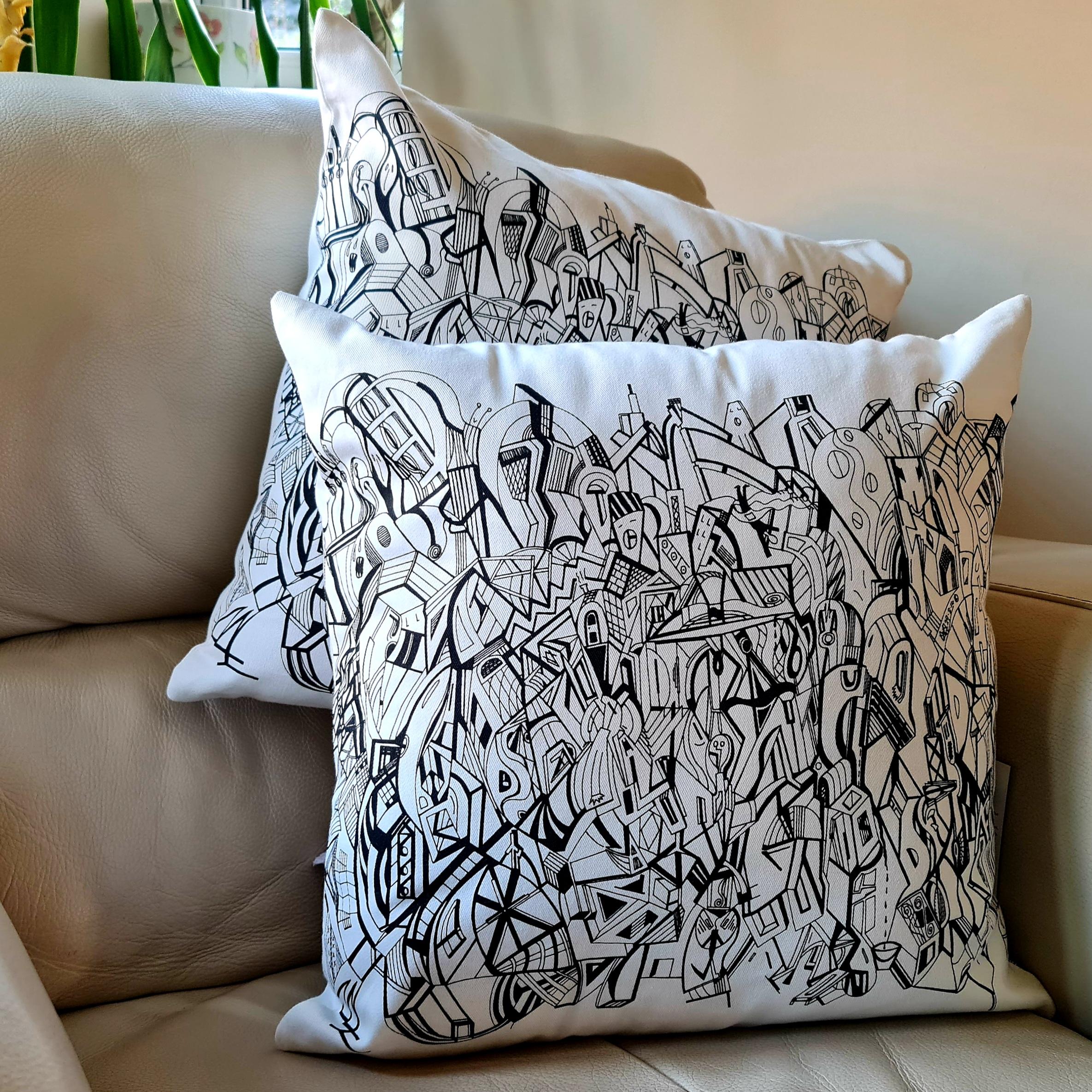 A cream coloured square cushion with the black artwork of Jason Clarke printed on the front