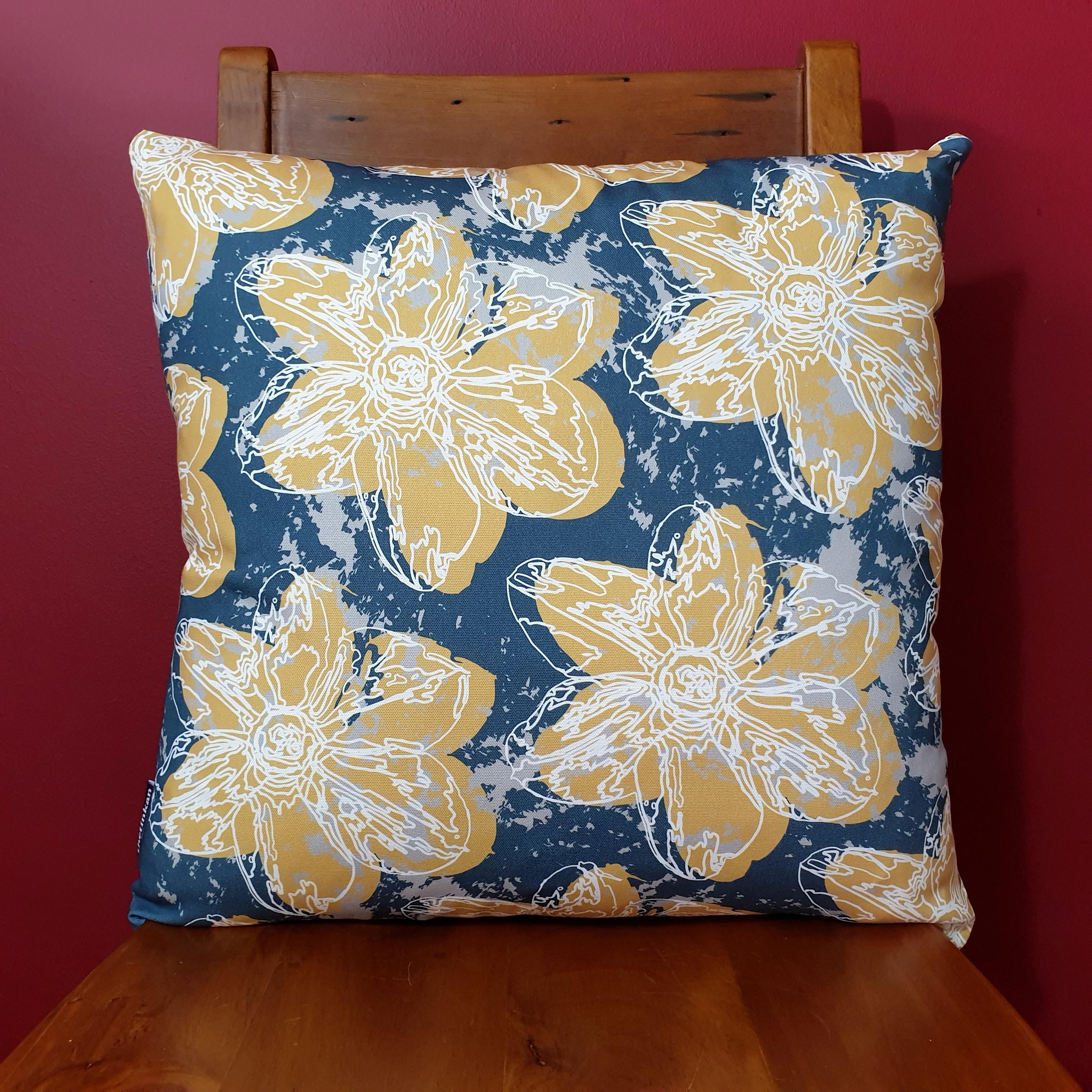 Double-sided 51cm square Flower Splash cushion designed by thetinkan. Mustard yellow narcissus flower with white traced outline set within an oxford blue background with pale grey paint splashes. Available with an optional luxury cushion inner pad. VIEW PRODUCT >>