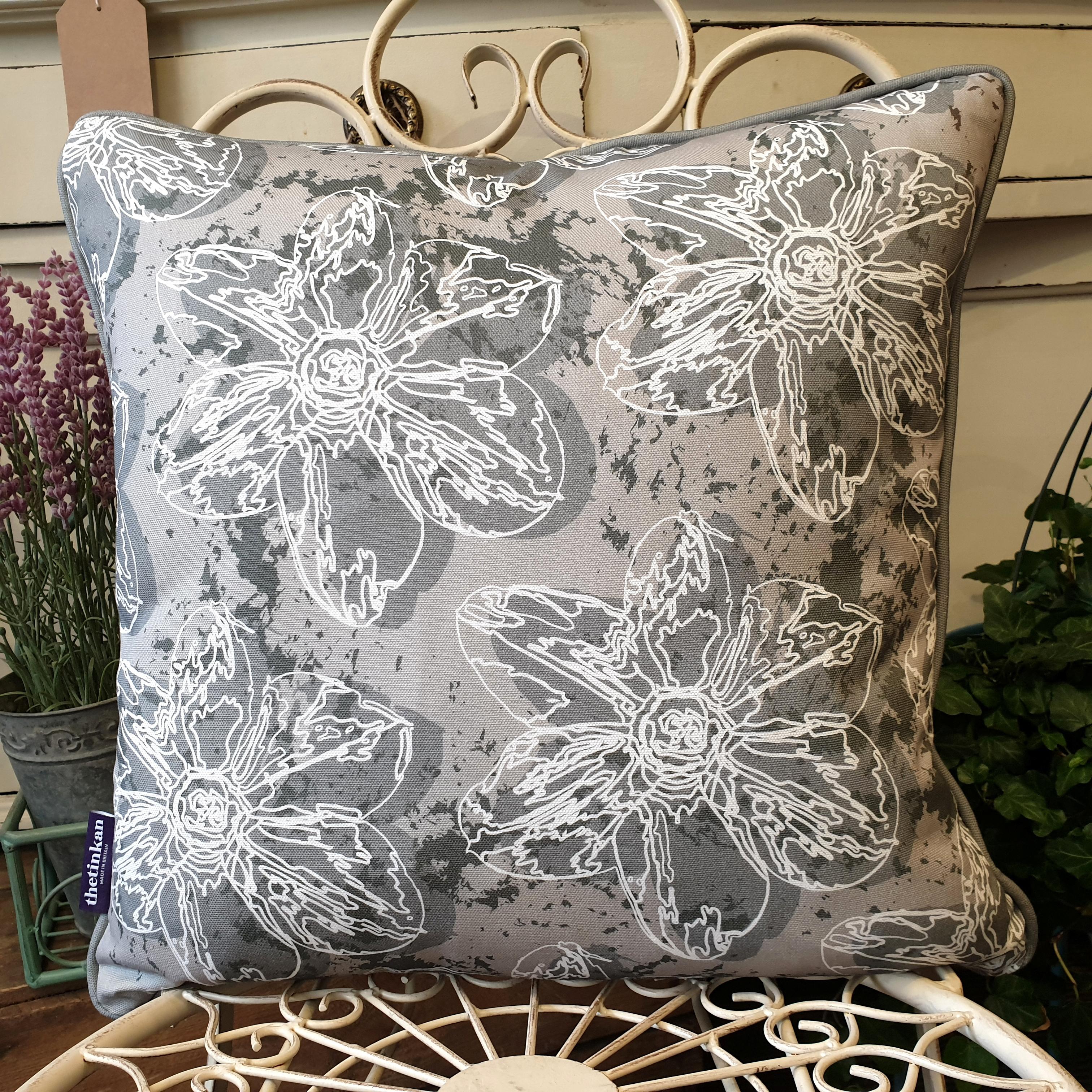 Double-sided 45cm square Flower Splash cushion designed by thetinkan. Dark grey narcissus flower and dark grey piping with white traced outline set within a grey background with charcoal grey paint splashes. Available with an optional luxury cushion inner pad. VIEW PRODUCT >>