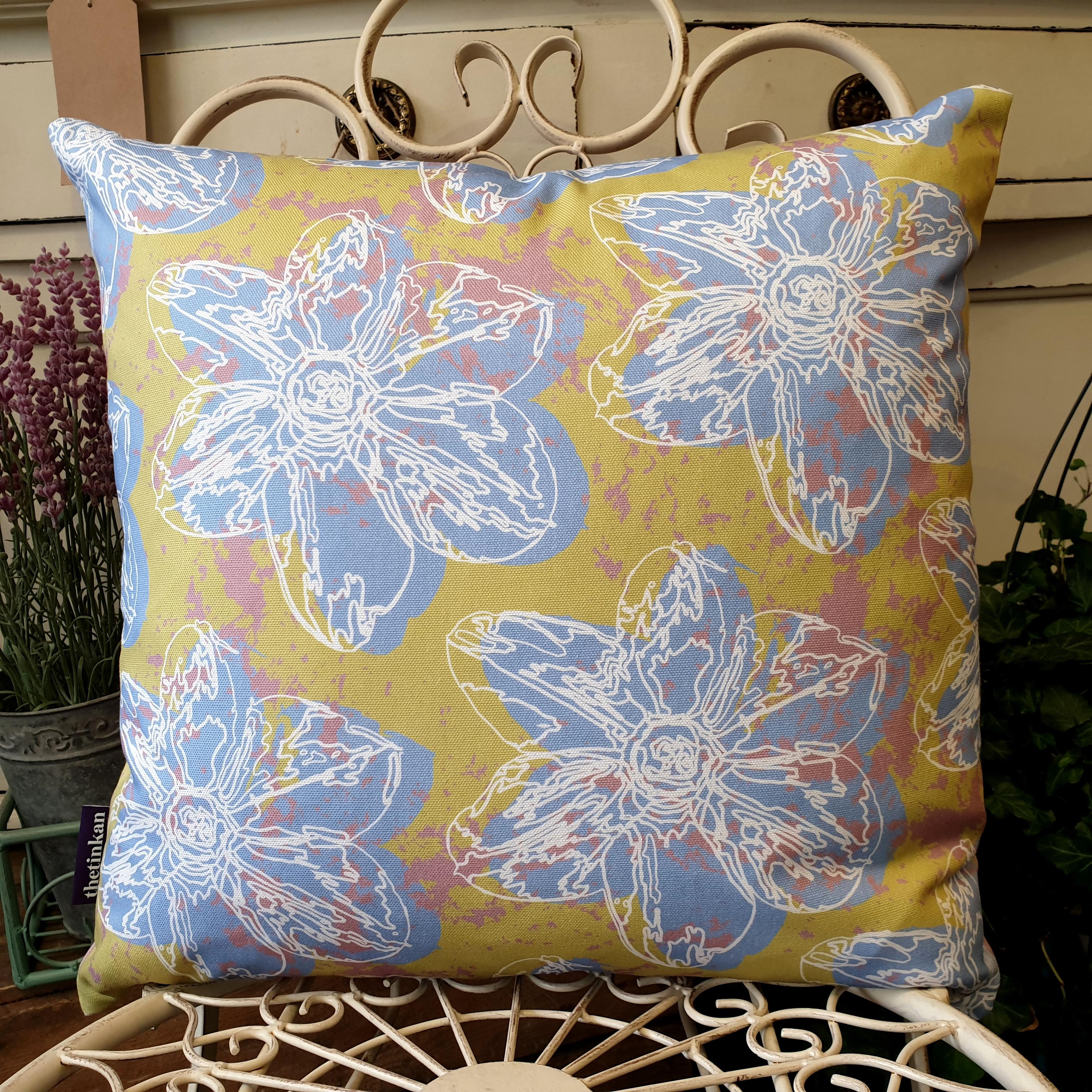 Double-sided 45cm square Flower Splash cushion designed by thetinkan. Pale blue narcissus flower with white traced outline set within a light olive green background with salmon pink paint splashes. Available with an optional luxury cushion inner pad. VIEW PRODUCT >>