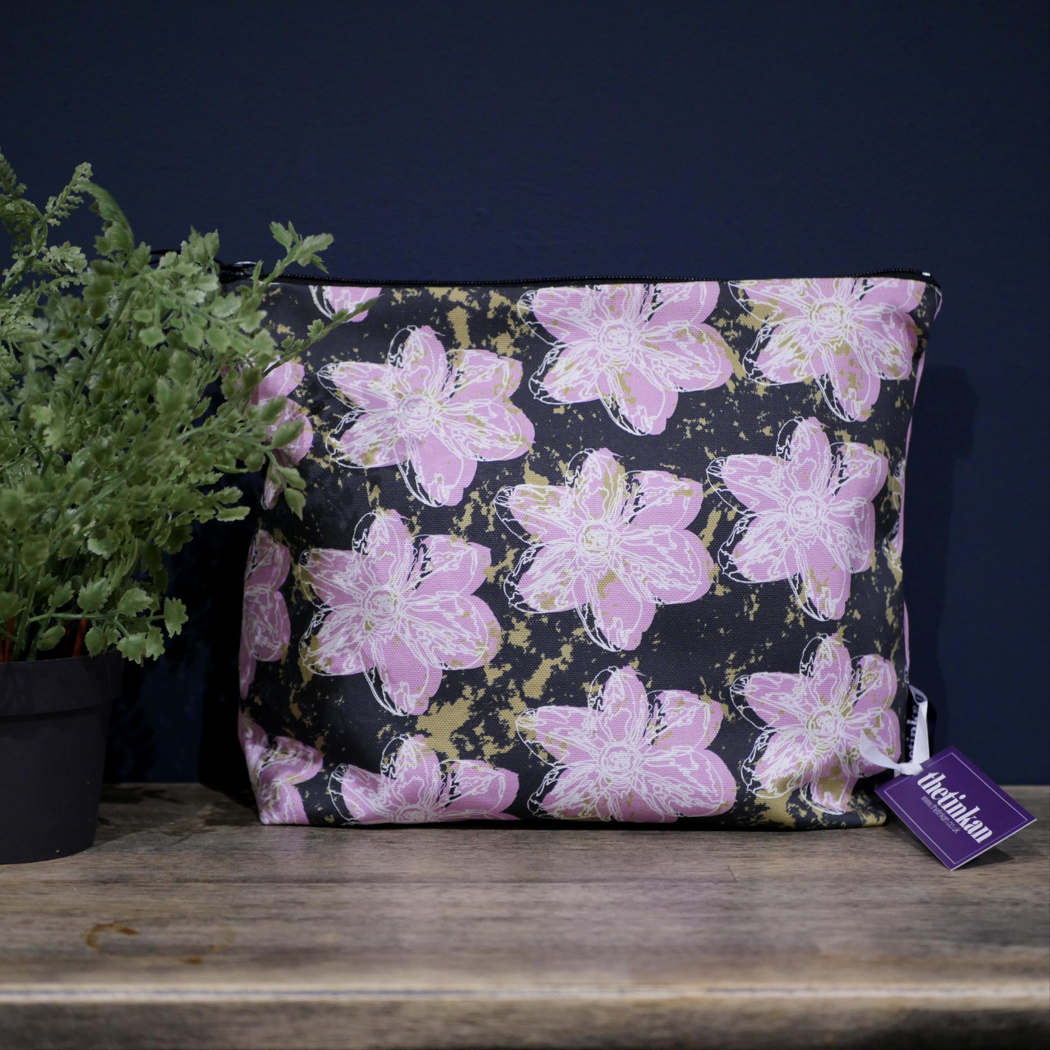 Candy pink flower with a matching coloured reverse, set on a dark charcoal grey background with an olive green colour splash. Designed by thetinkan, the flower splash travel beauty washbag featuring the white traced outline of a?narcissus flower is made from panama cotton with black waterproof lining and matching black sturdy zip. Generously sized for all your travel or home needs.? VIEW PRODUCT >>