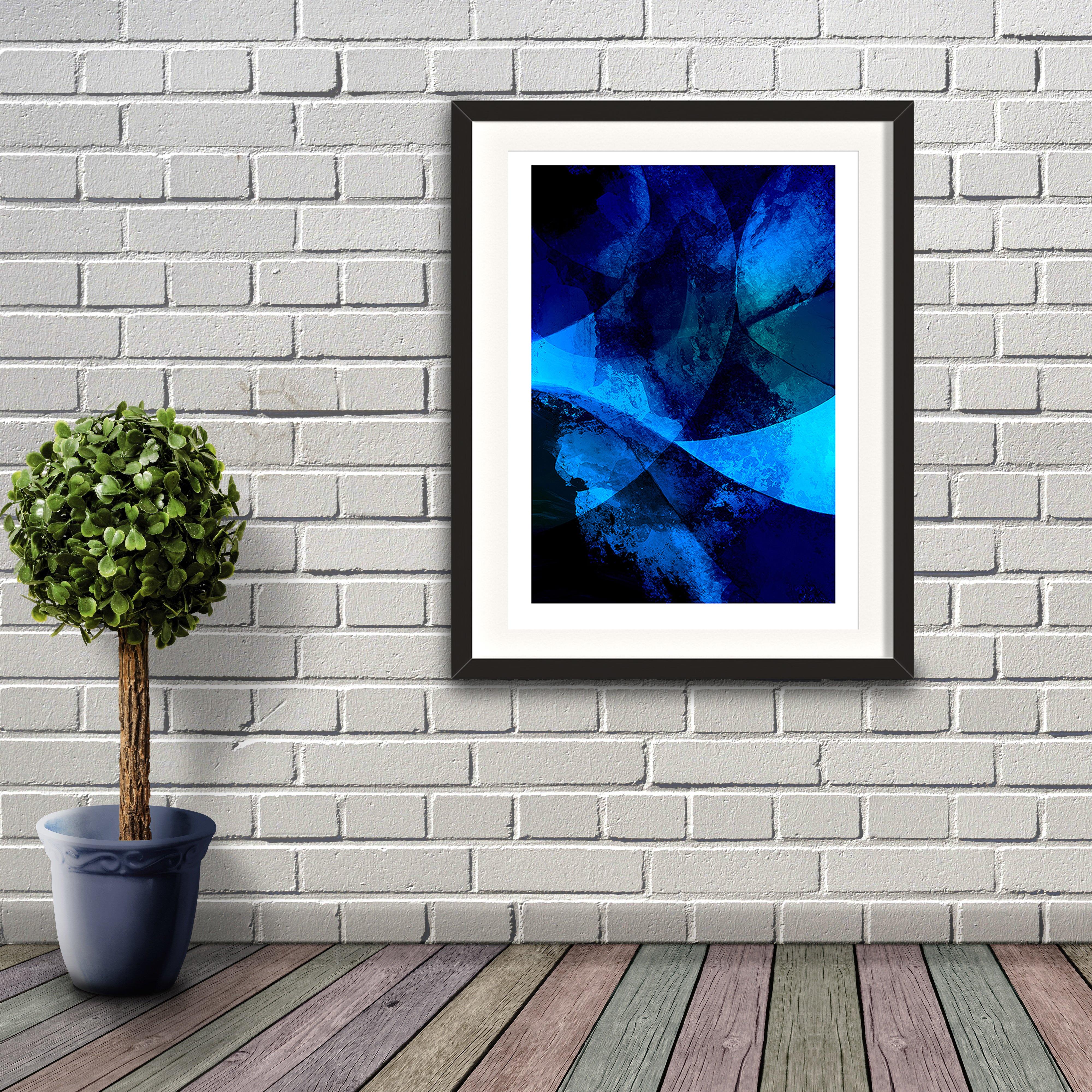 A digital painting by Lily Bourne printed on eco fine art paper titled Blue Passion From Within showing a series of curved lines and textures coloured shade of blue and black. Artwork is shown shown framed on a brick wall.