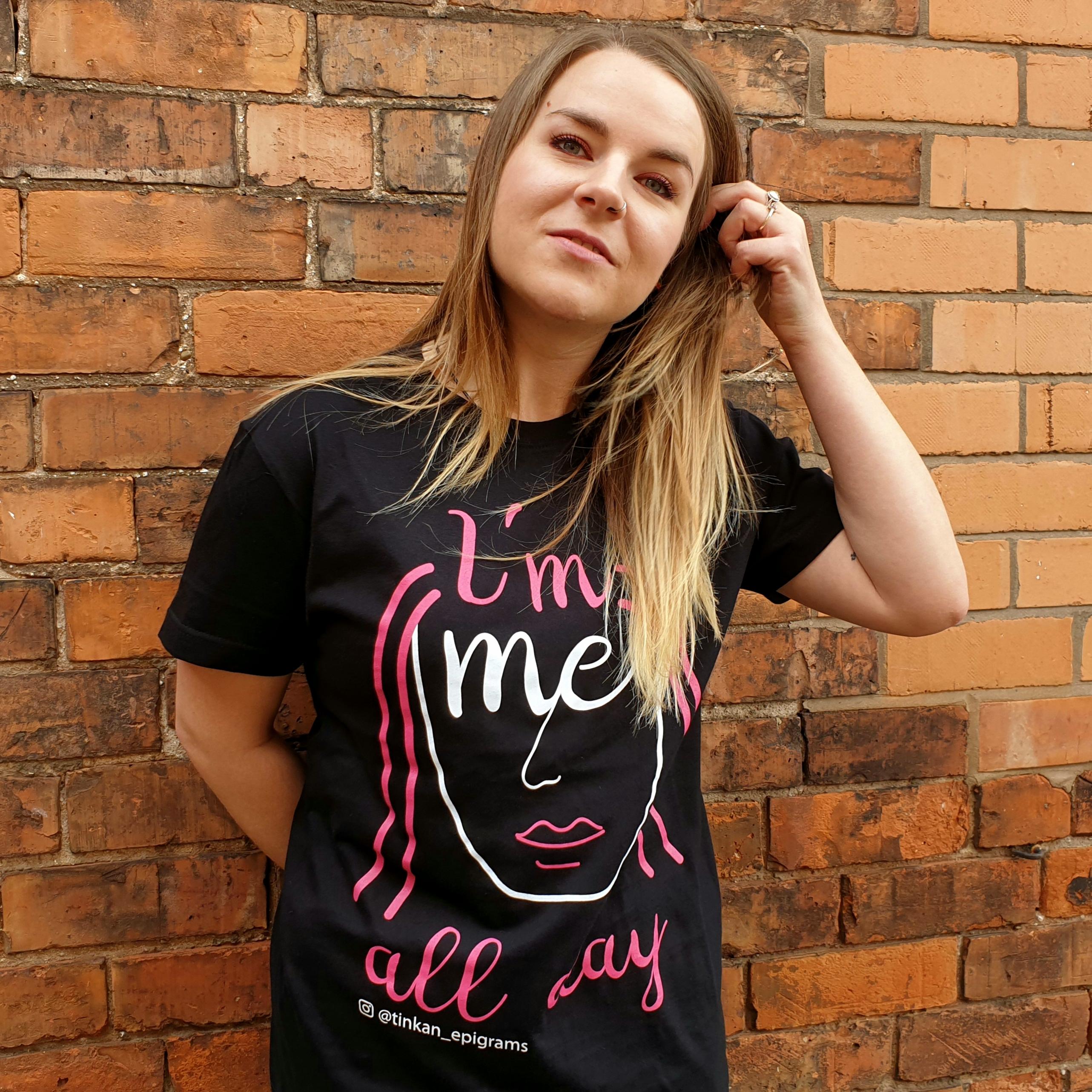 Adult female wearing black t-shirt with white handdrawn face with pink hair with the words I'm Me All Day printed. Designed by thetinkan. VIEW PRODUCT >>