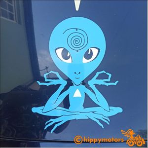 pale blue Alien with large human like eyes decal meditating on bonnet of a car