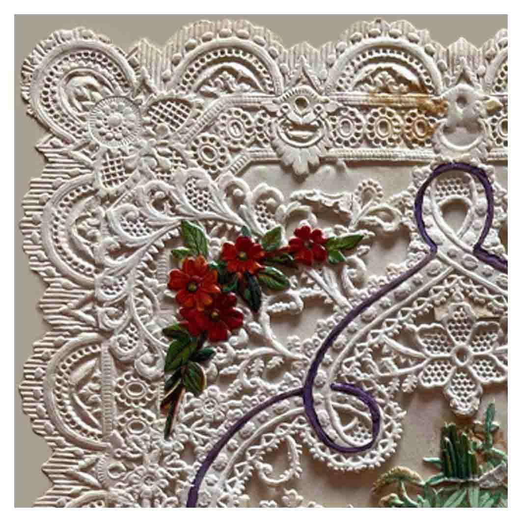 A pierced and embossed paper that looks like lace forms the edge of this Victorian Valentine's Day card. A small bunch of red flowers decorates the corner.