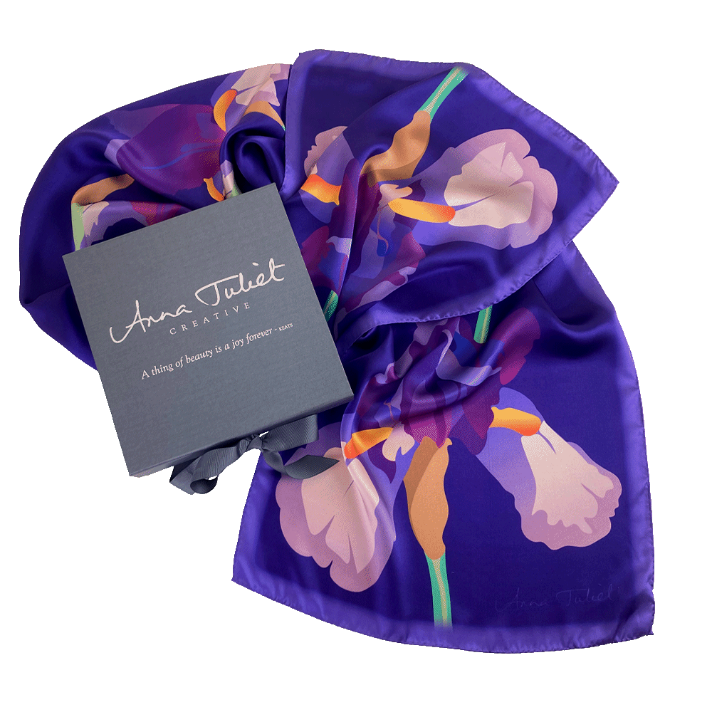 Floral pure silk scarf draped around a branded pewter-coloured gift box. Limited edition Mauve Iris on Dark Blue by Anna Juliet Creative.