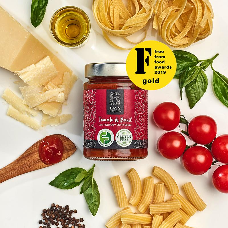 A jar of Bay's Kitchen award-winning Tomato & Basil sauce surrounded by its ingredients