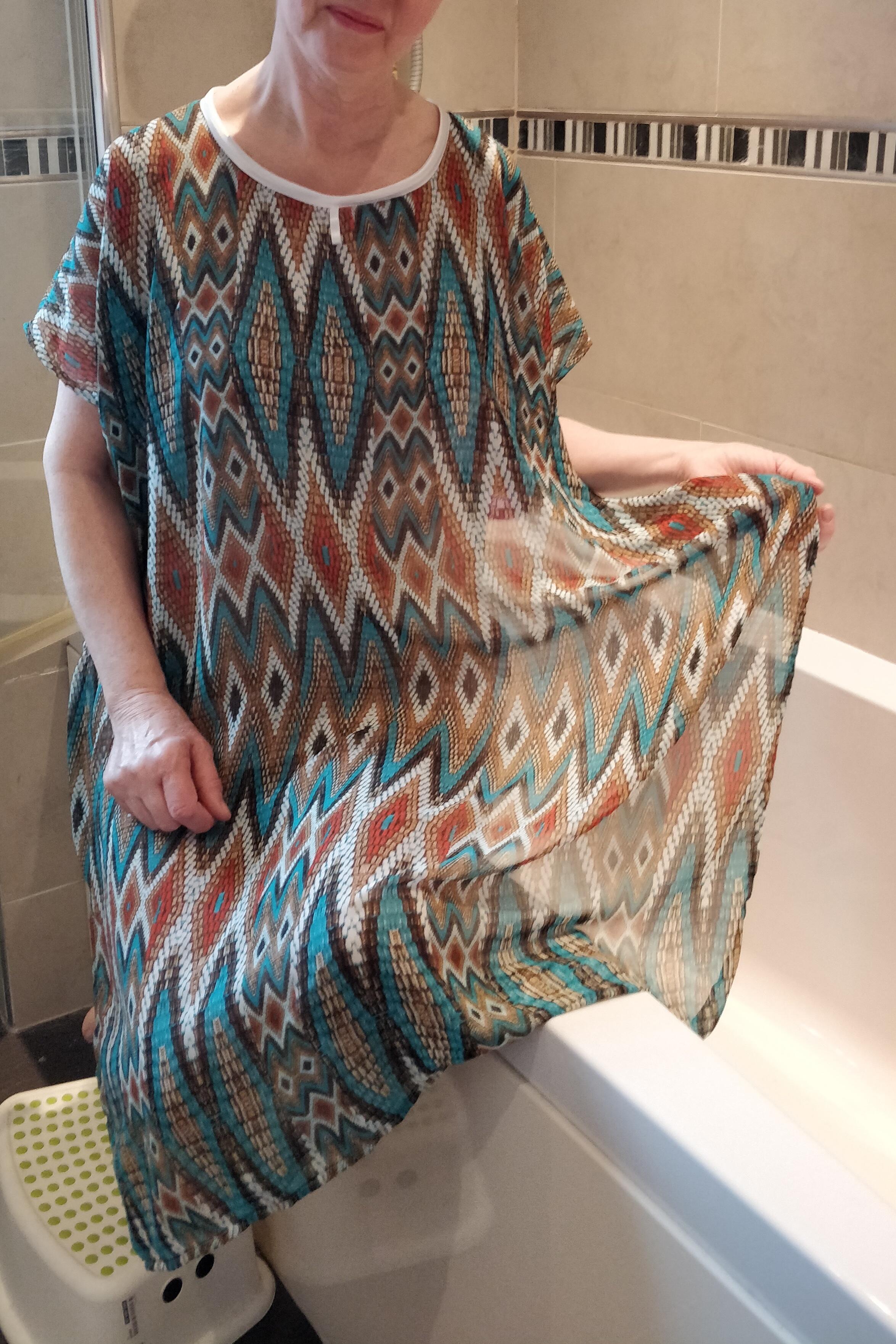 Teal/tan Aztec-type design NeverNaked(tm) Shower Drapron® - dementia dignity showering cape drapes over shoulders to be left on whilst showering so dignity is maintained. No sleeves. Small magnetic fastening at back