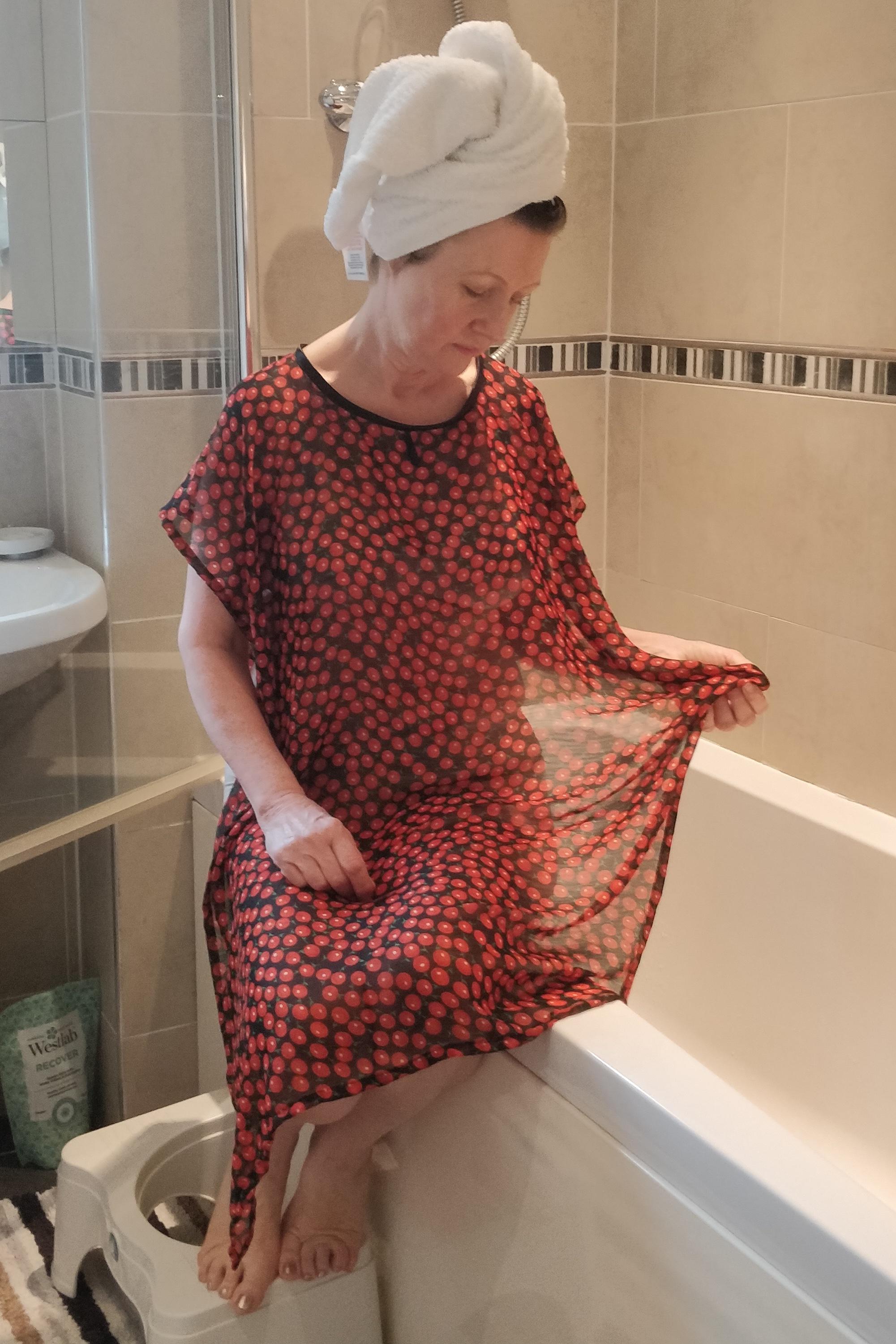 Black/Ruby NeverNaked(tm) Shower Drapron® to provide modesty, dignity and privacy whilst being helped to shower or bathe. Shower modesty wear. Bathing modesty gown. Lightweight crepe chiffon. Slips over shoulders - No sleeves. Magnetic fastening at back