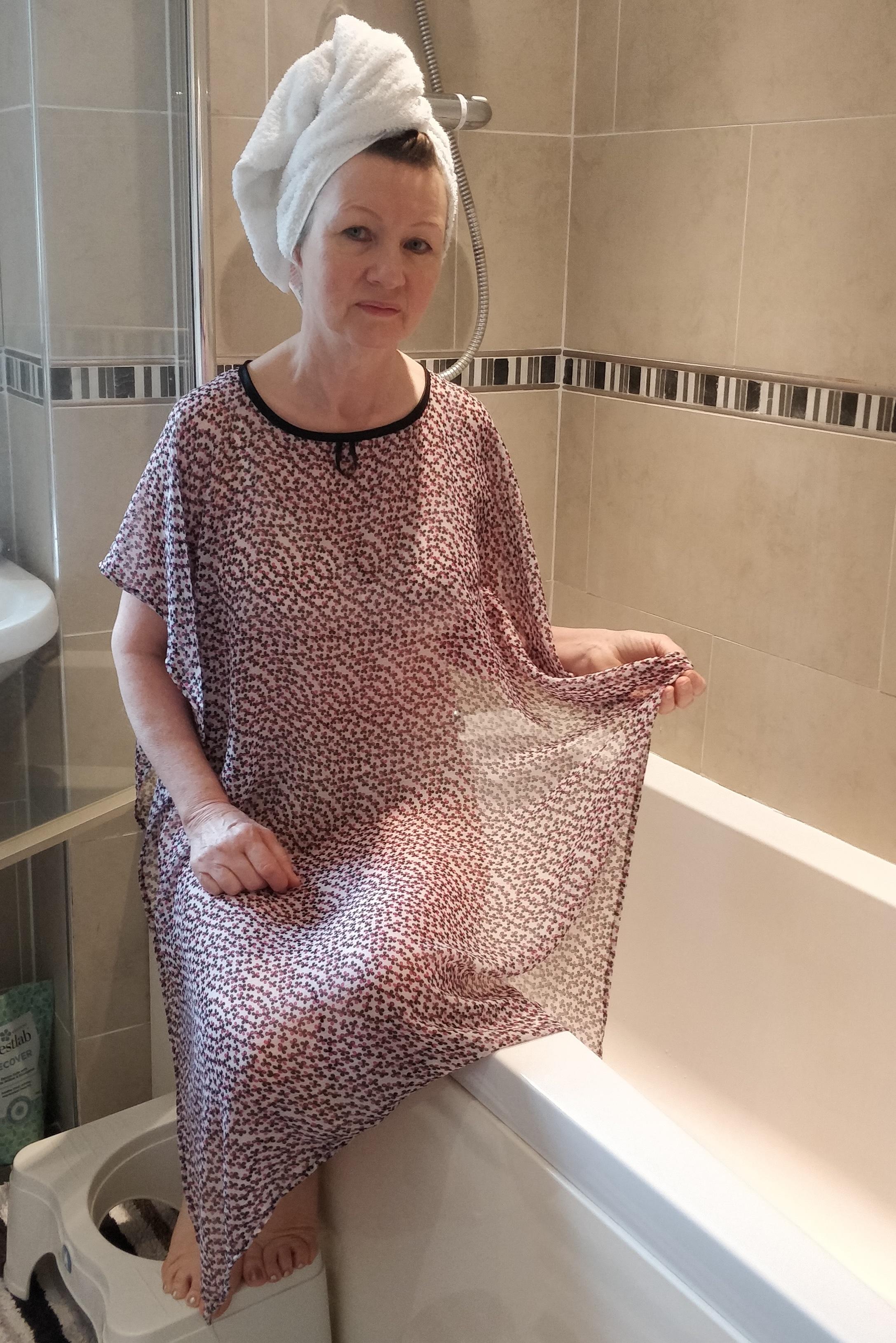 Ditsy print NeverNaked(tm) Shower Drapron® to provide modesty, dignity and privacy whilst being helped to shower or bathe. Shower modesty wear. Bathing modesty gown. Lightweight crepe chiffon. Slips over shoulders - No sleeves. Magnetic fastening at back
