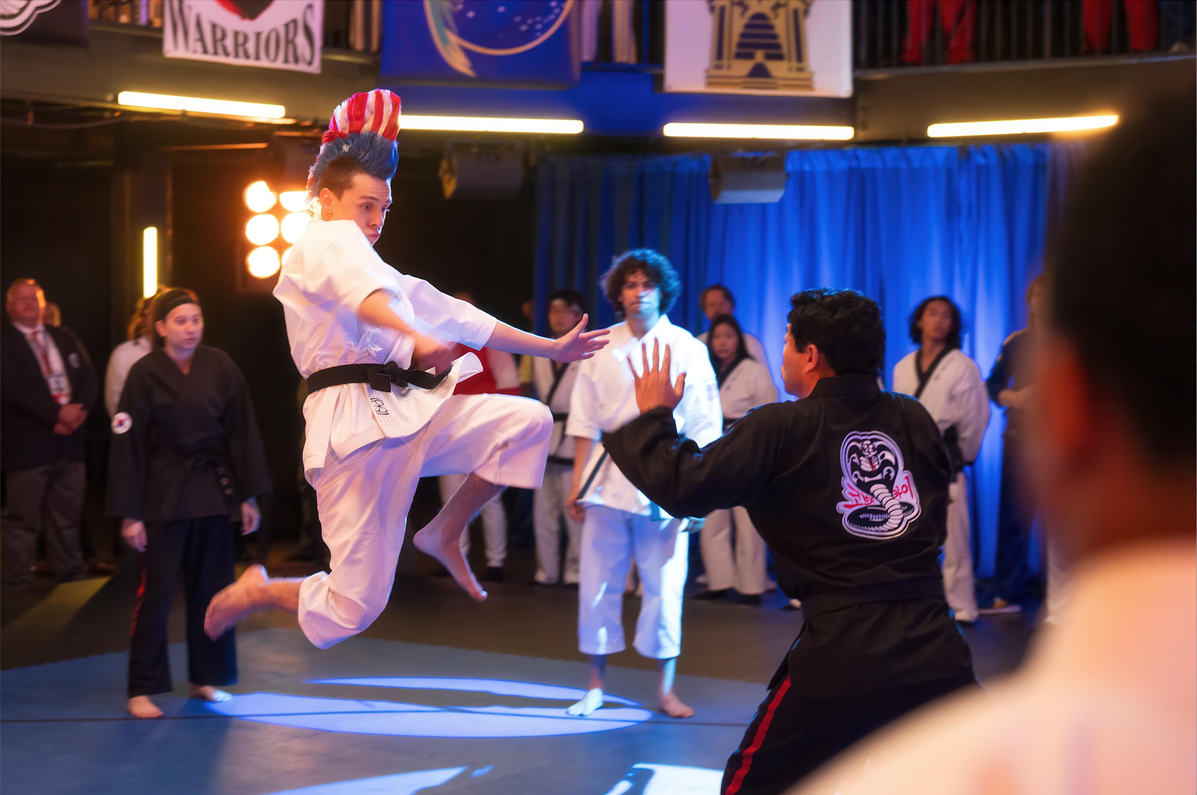 Hawk (Jacob Bertrand) delivering a jumping knee strike in Cobra Kai