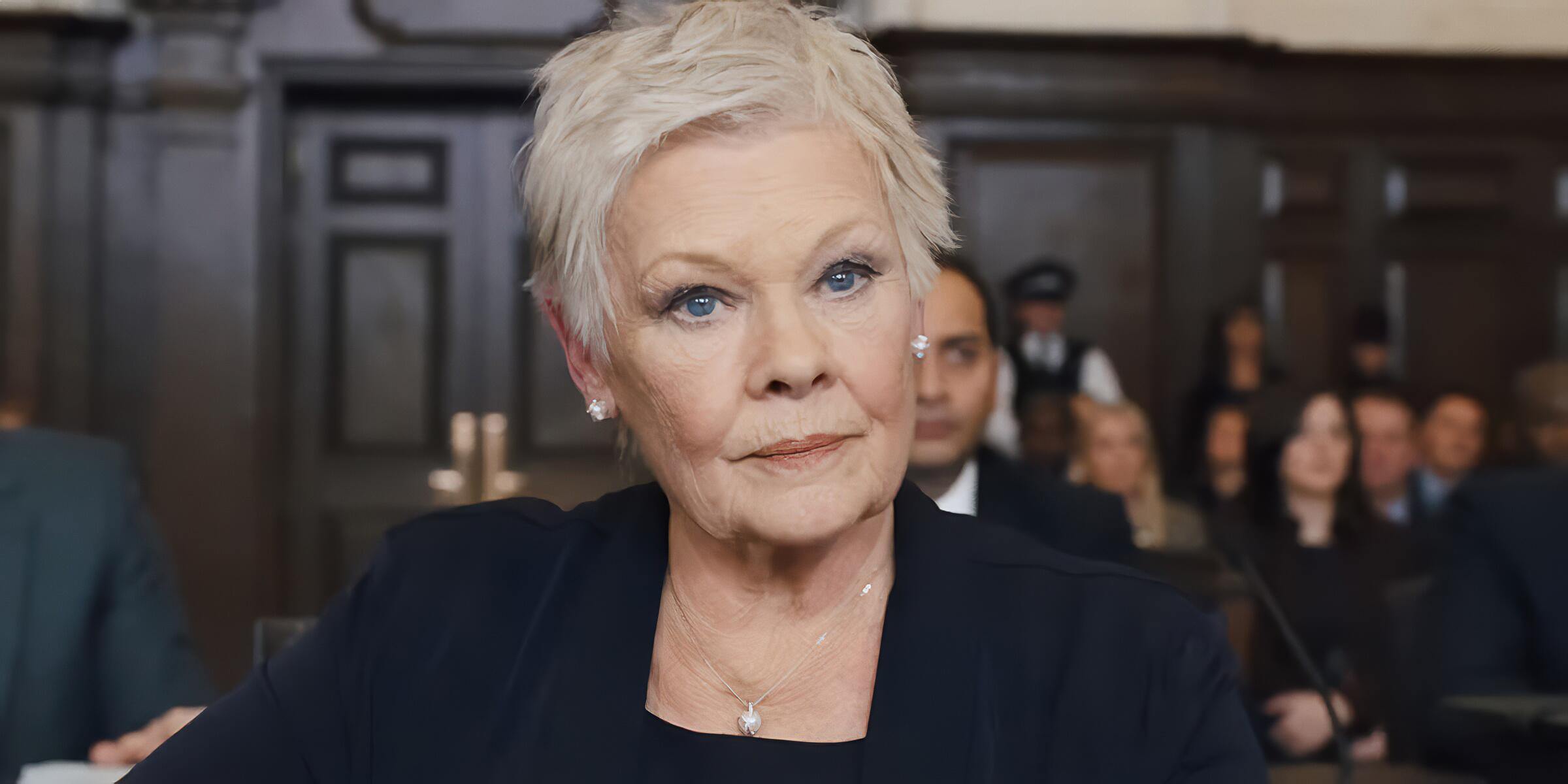 Judi Dench as M in Skyfall, portraying the character's strength and vulnerability during the public inquiry sequence.
