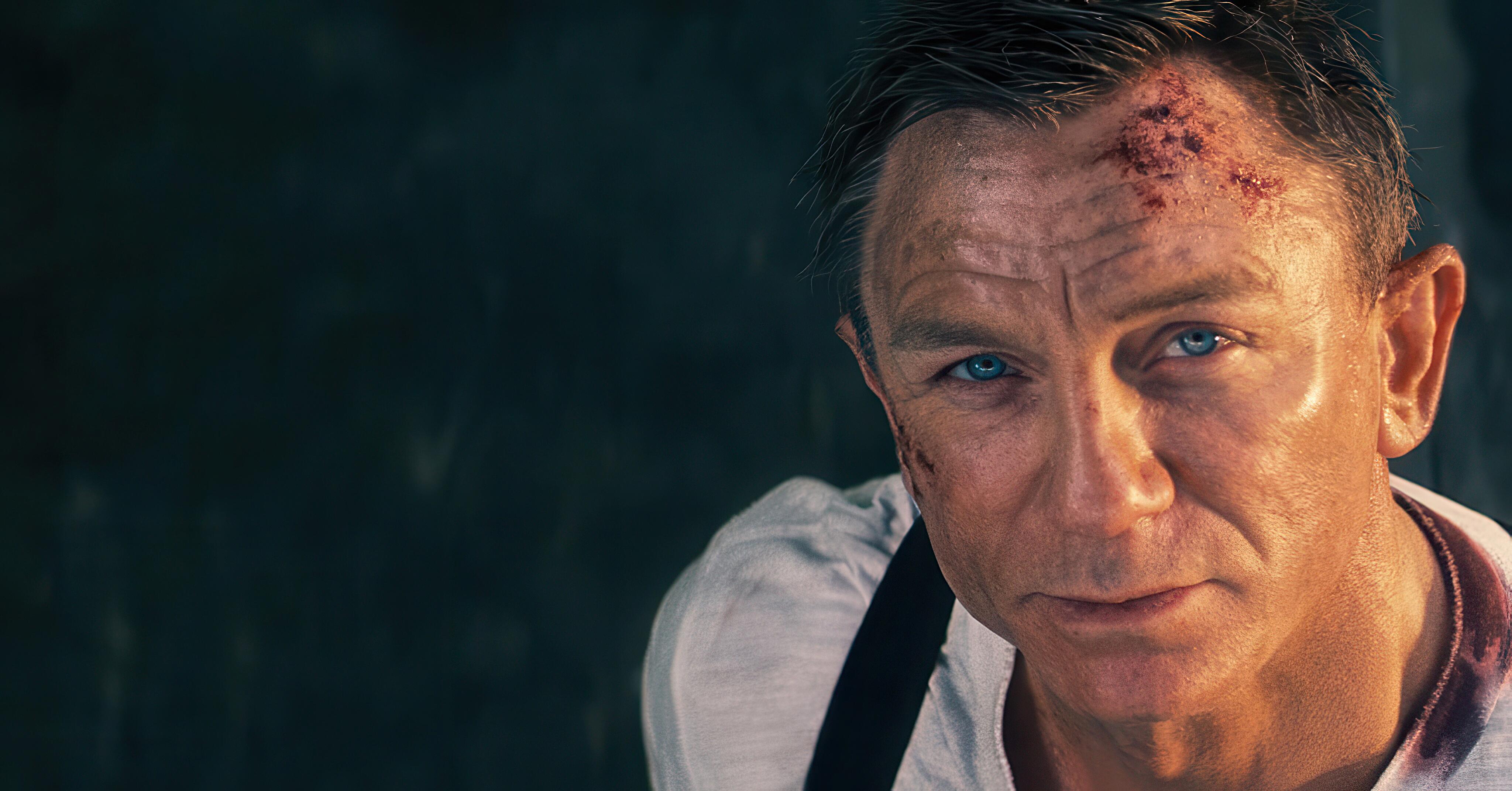 An image of James Bond (Daniel Craig) looking calmly skyward from the climax of ‘No Time to Die’. As ballistic missiles approach, Bond climbs to the top of the missile platform, accepting his fate. He speaks to Madeleine via radio, in a tender, heartbreaking conversation in which they both confess their love. She confirms that Mathilde is indeed his daughter. Moments later, the missiles strike the island, and Bond is engulfed in the explosion.