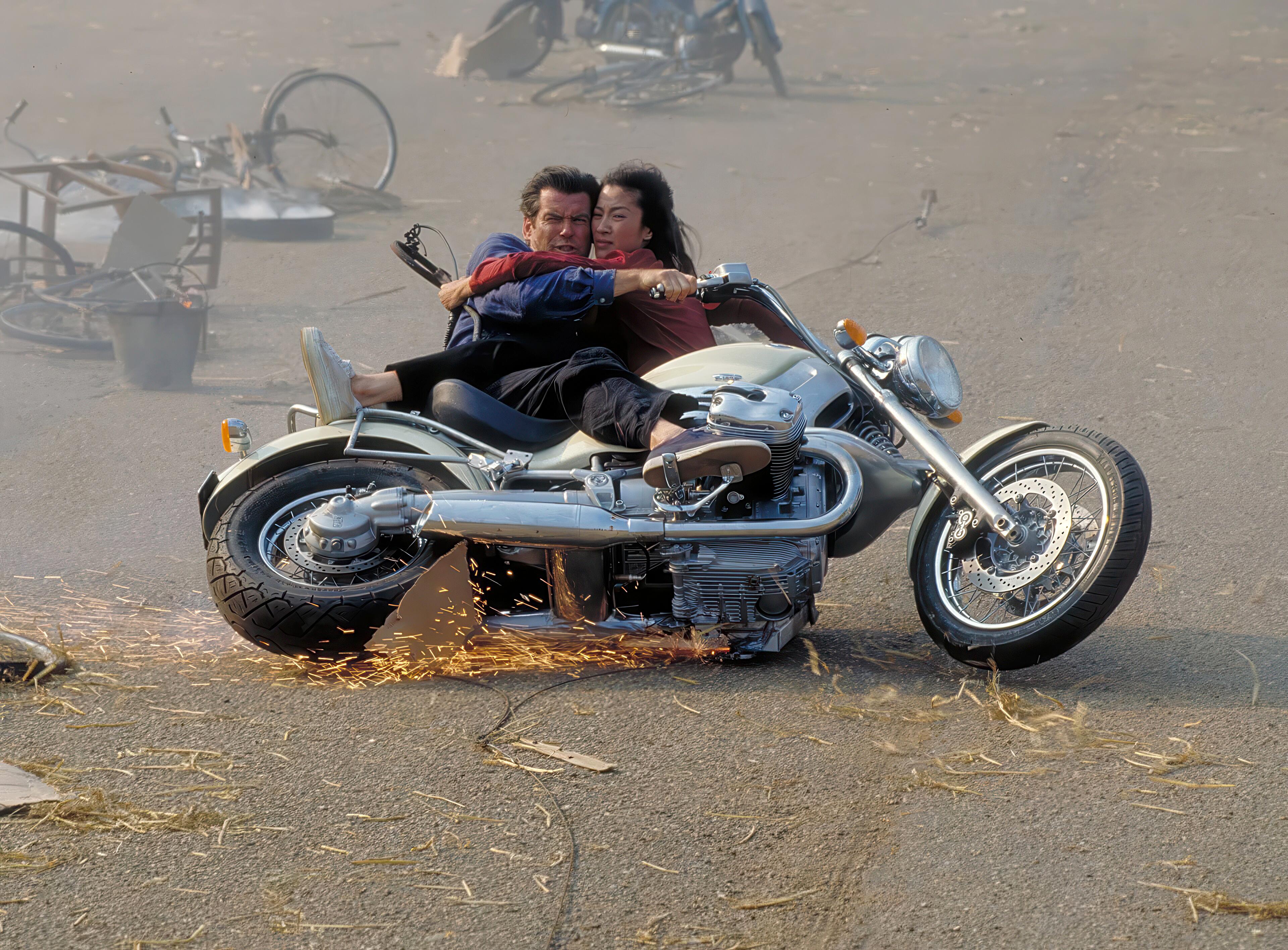 Pierce Brosnan (James Bond, 007) and Michelle Yeoh (Wai Lin) powersliding a motorcycle during the exciting bike vs helicopter chase in Tomorrow Never Dies (1997)