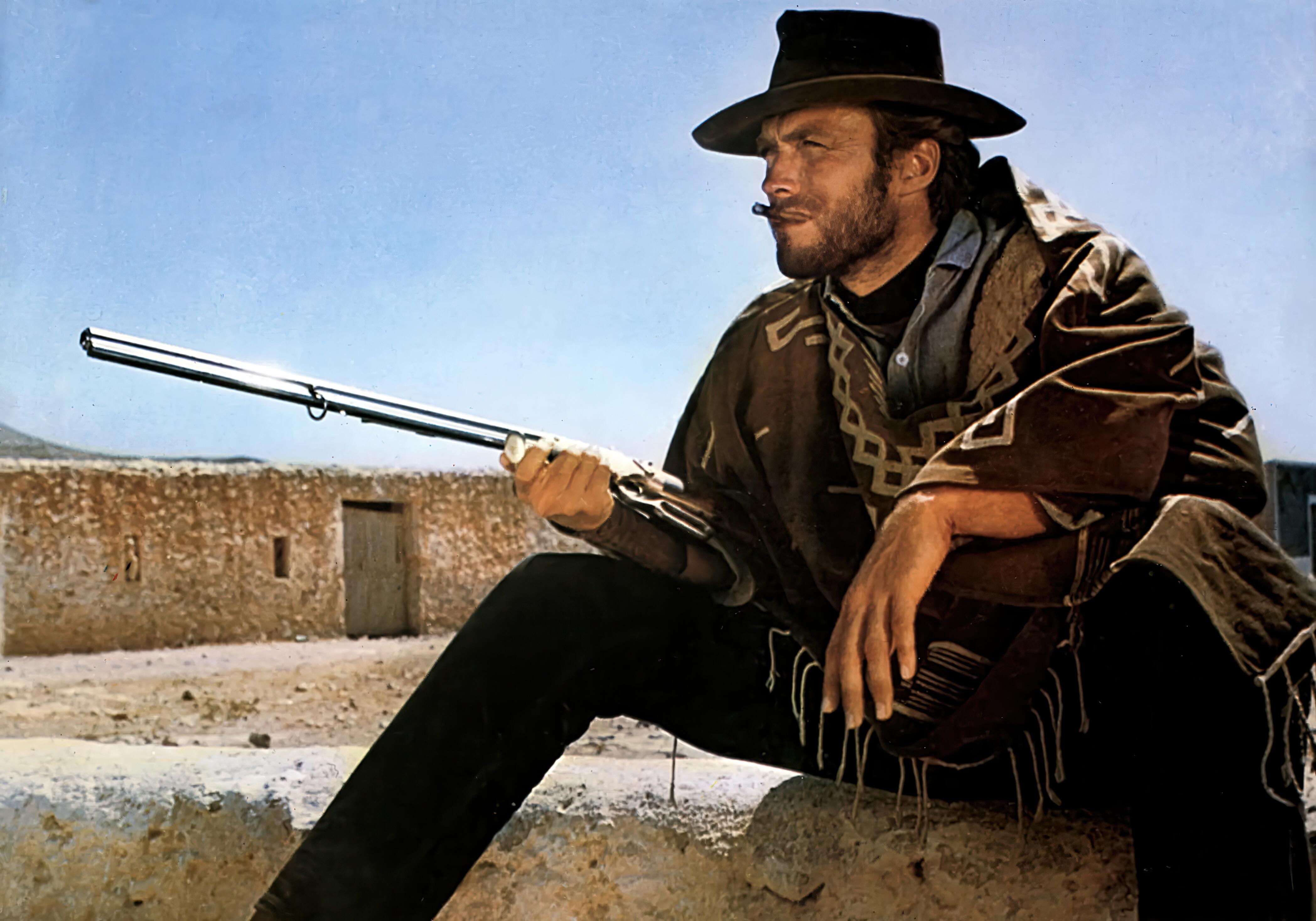 Clint Eastwood posing as “The Man with No Name”, although obliquely referred to as ‘Manco’ in Sergio Leone’s For a Few Dollars More (1965). Clint Eastwood's character is wearing an outfit that became iconic in Western cinema. His most recognizable piece is a brown Mexican-style poncho with white geometric patterns, often draped to conceal weapons. He pairs it with a weathered brown cowboy hat, , dark trousers, and leather boots with spurs. A low-slung gun belt and a Colt revolver complete the look, along with his ever-present cigarillo. The ensemble reflects his rugged, silent, and deadly persona, helping to redefine the cinematic cowboy as a morally ambiguous antihero. He is holding a Volcanic Repeater rifle.