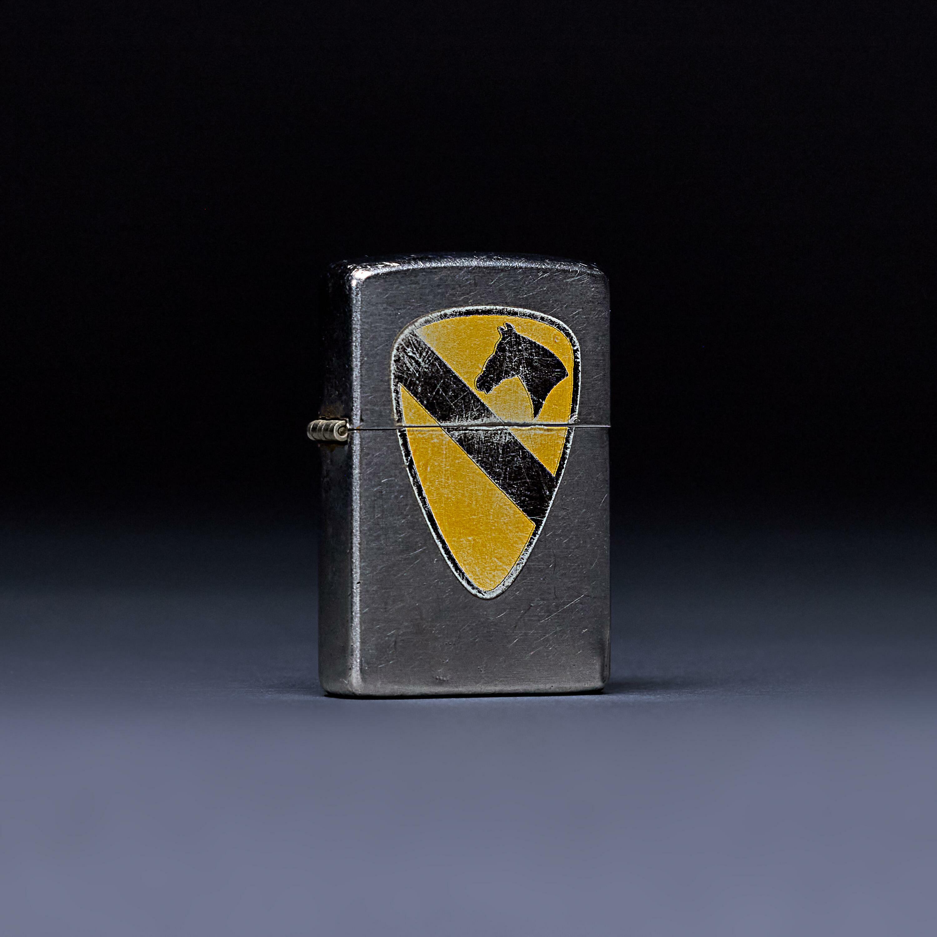 Walt’s screen-used Ranger Zippo lighter from Gran Torino, featuring a yellow and black cavalry insignia.