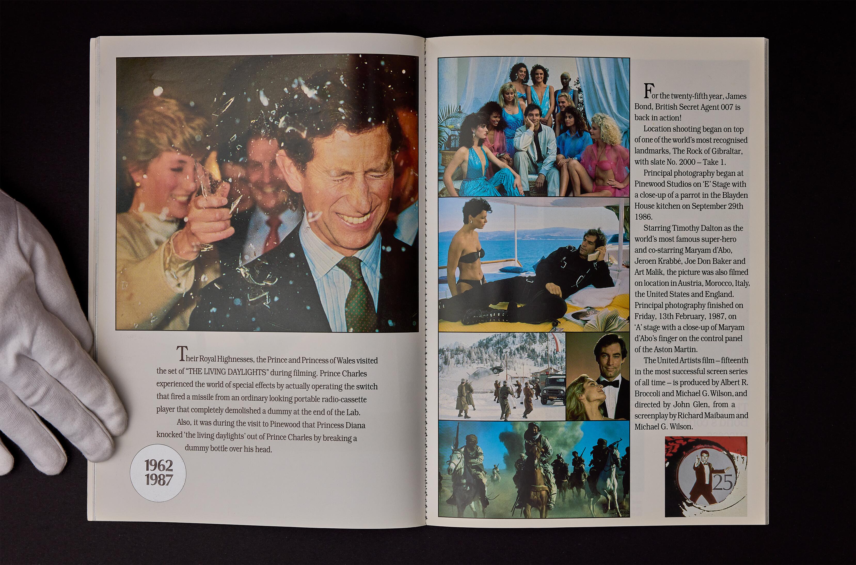 A spread from the highly collectable Royal World Charity Premiere Brochure for the James Bond movie, The Living Daylights, attended by TRH The Prince and Princess of Wales on June 29th, 1987. The brochure includes the famous photo of Princess Diana smashing a break-away glass bottle over the head of Prince Charles during a visit to Pinewood Studios in 1986. Available for sale at Kudos Memorabilia Ltd.