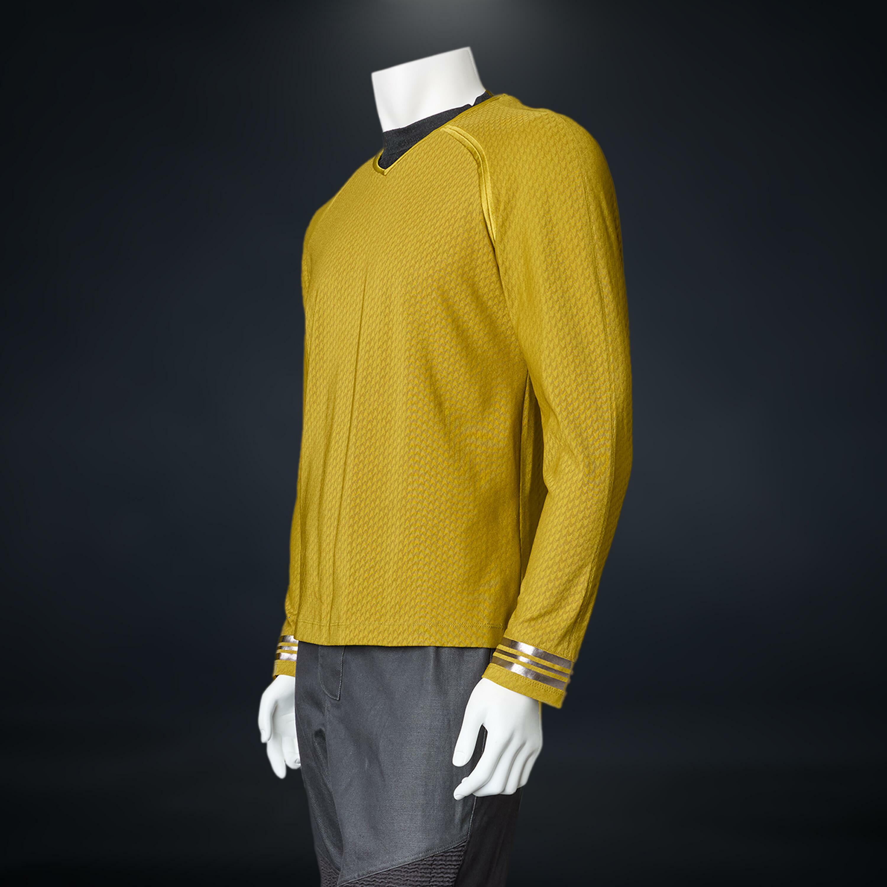 Captain Kirk’s command costume worn by Chris Pine in Star Trek Into Darkness, displayed on a mannequin with yellow Starfleet uniform top.