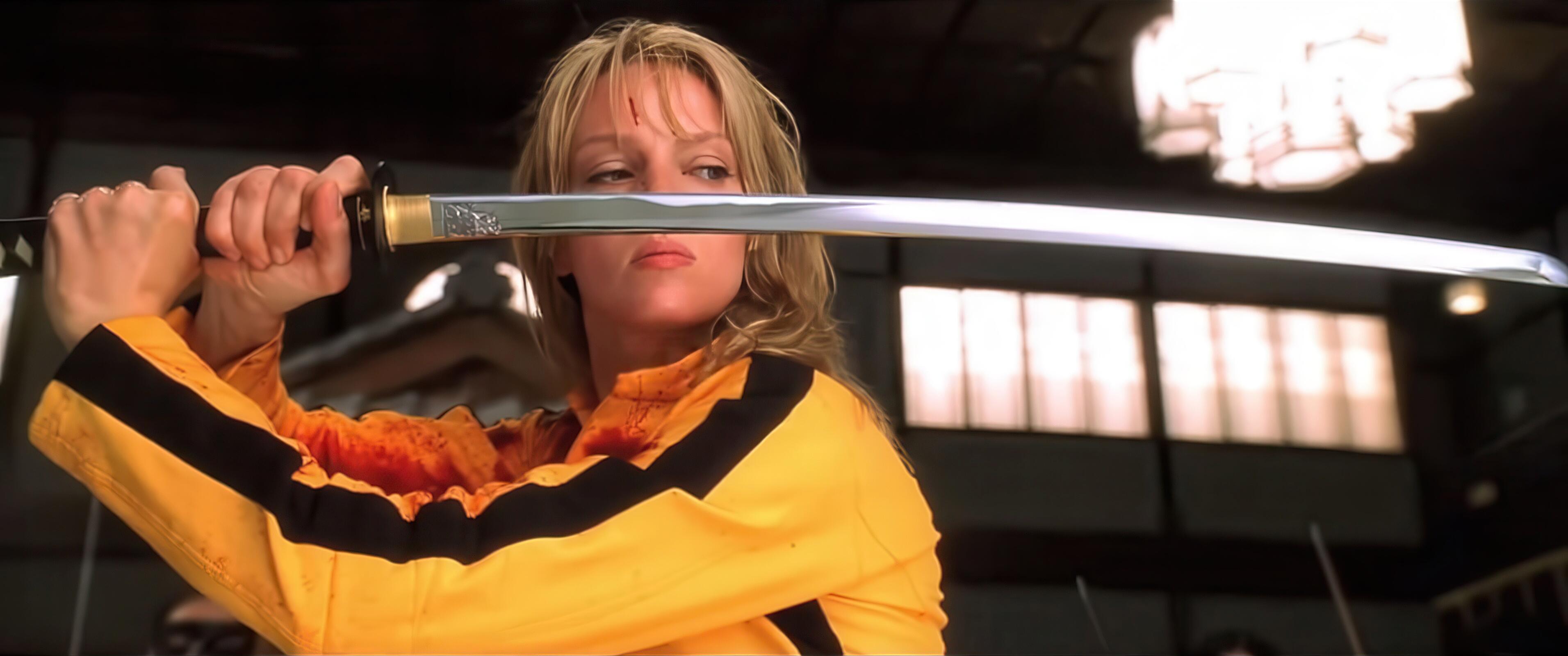 Actress Uma Thurman posing with a Japanese katana, as The Bride, in Quentin Tarantino’s Kill Bill (2003). The Bride’s sword is a custom-made katana crafted by the legendary swordsmith Hattori Hanzō. It’s not just a weapon—it’s a central symbol of vengeance, honour, and destiny in the story. It is engraved with Hattori Hanzō’s crest, signifying its origin and unmatched quality.