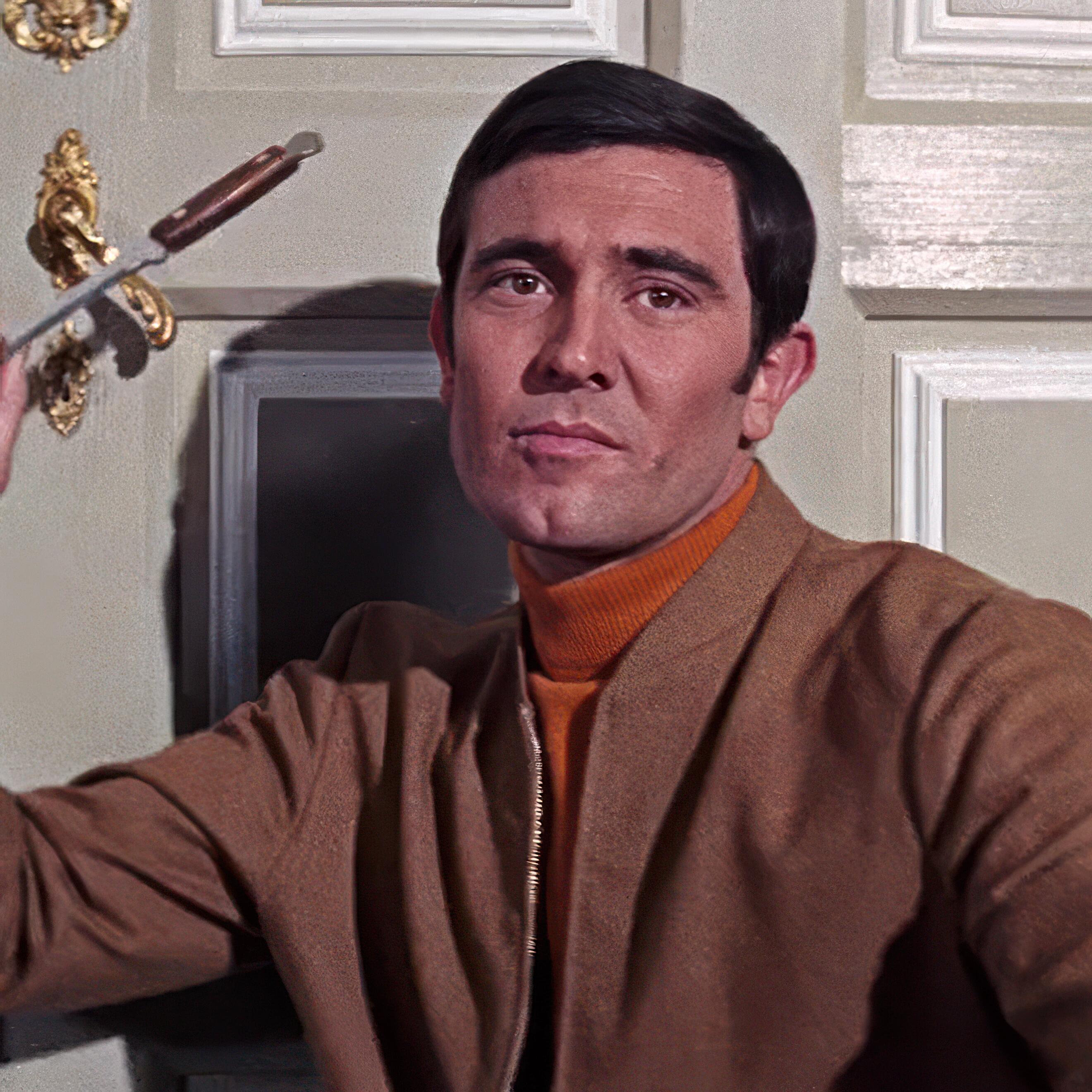 George Lazenby, as James Bond, poised to throw his iconic knife in On Her Majesty’s Secret Service (1969).