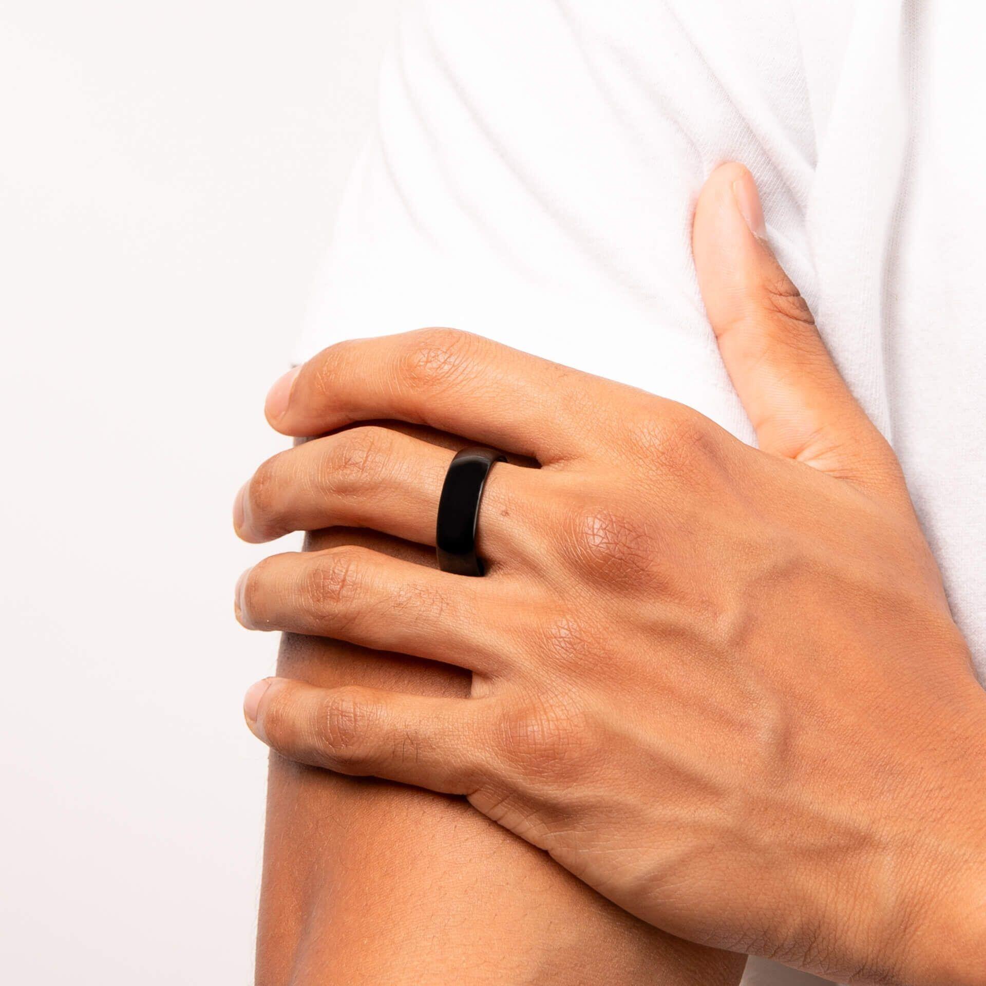 "8mm Comfort Feel Polished IP Black Plated Tungsten Ring featuring sleek black plating and Anchor Cert Protect skin safety, presented in a branded suede wallet."