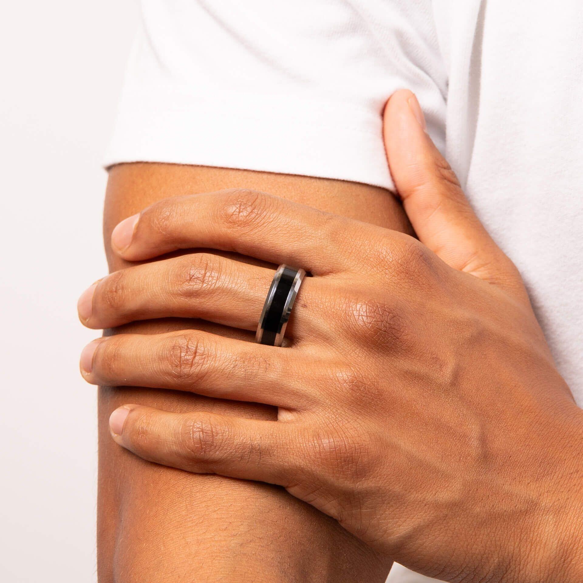 "8mm Tungsten Ring with Black Enamel Inlay featuring a bold black enamel stripe, Anchor Cert Protect skin safety, presented in a branded suede wallet."
