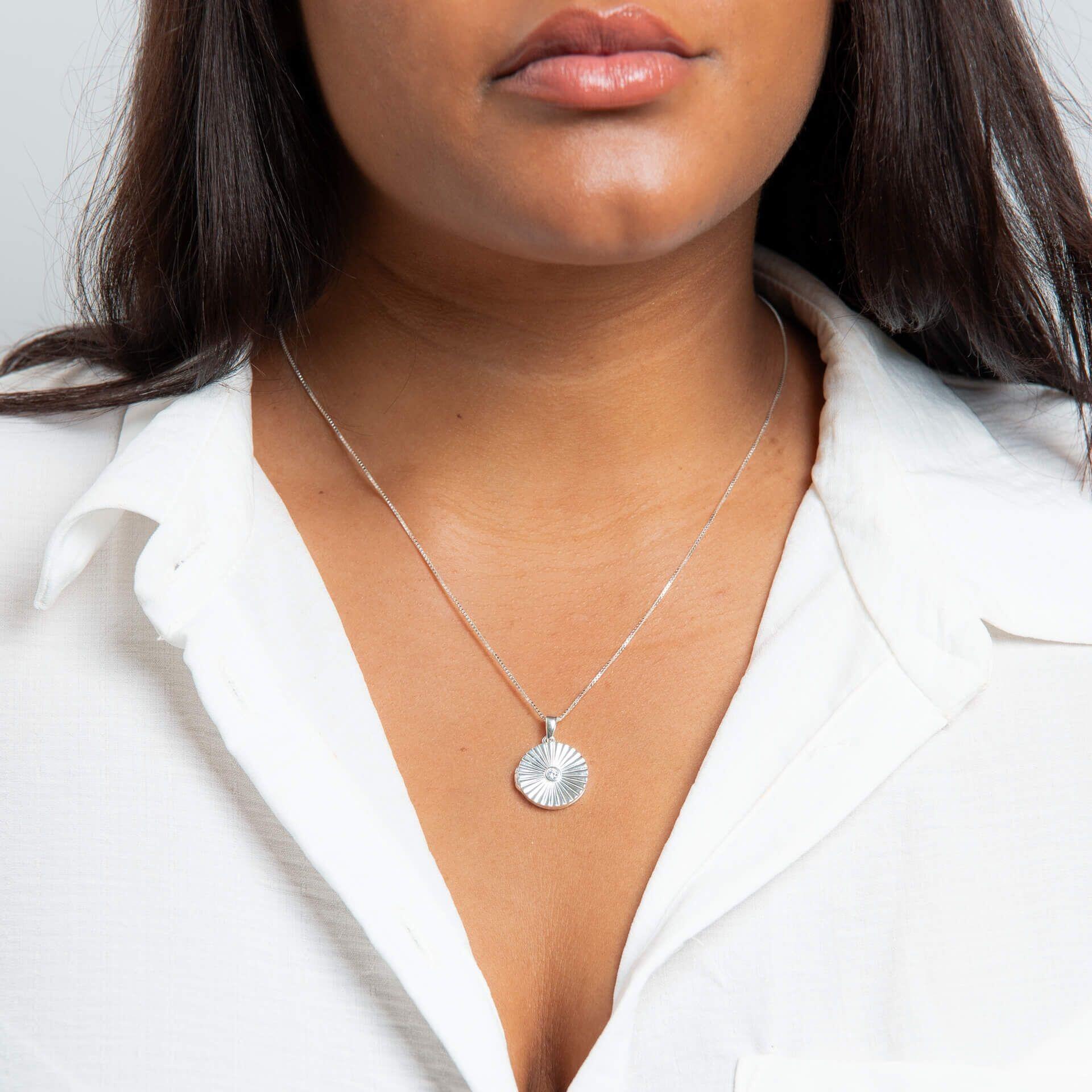 "Recycled sterling silver sunburst locket pendant with cubic zirconia, personalised engraving, and AnchorCert Protect skin-safe jewellery from Gold and Diamonds"