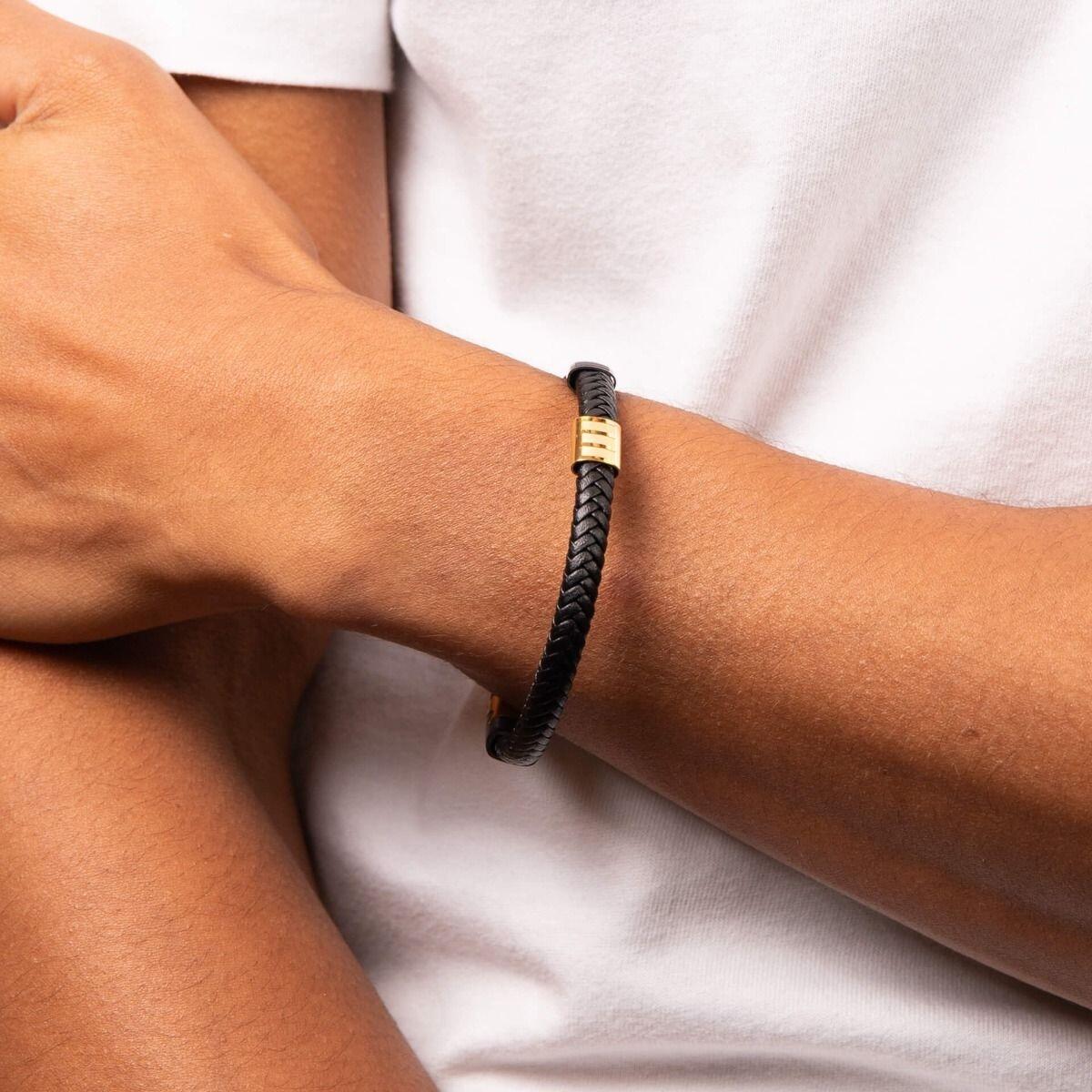 "fredbennett® Black Leather Bracelet – A modern and stylish men’s bracelet crafted from black braided leather, featuring black IP and yellow gold-plated stainless steel accents. Perfect for everyday wear or stacking. AnchorCert® certified and presented in luxury suede packaging from Gold and Diamonds."