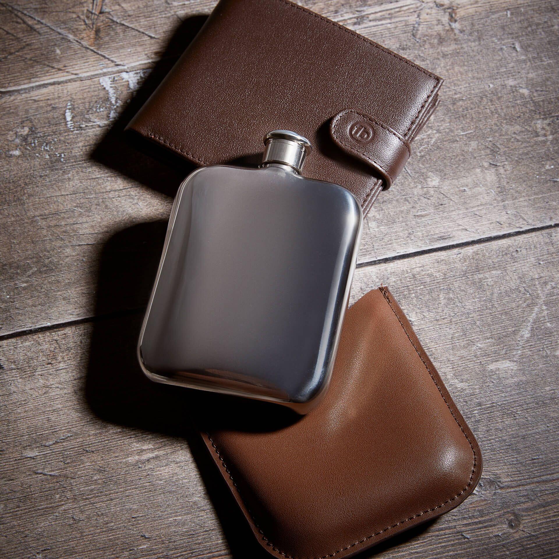 "fredbennett® Stainless Steel Hip Flask with genuine brown leather sleeve – fully personalisable with free engraving on both flask and sleeve. A perfect gift for groomsmen, the groom, or milestone occasions. Available at Gold and Diamonds."