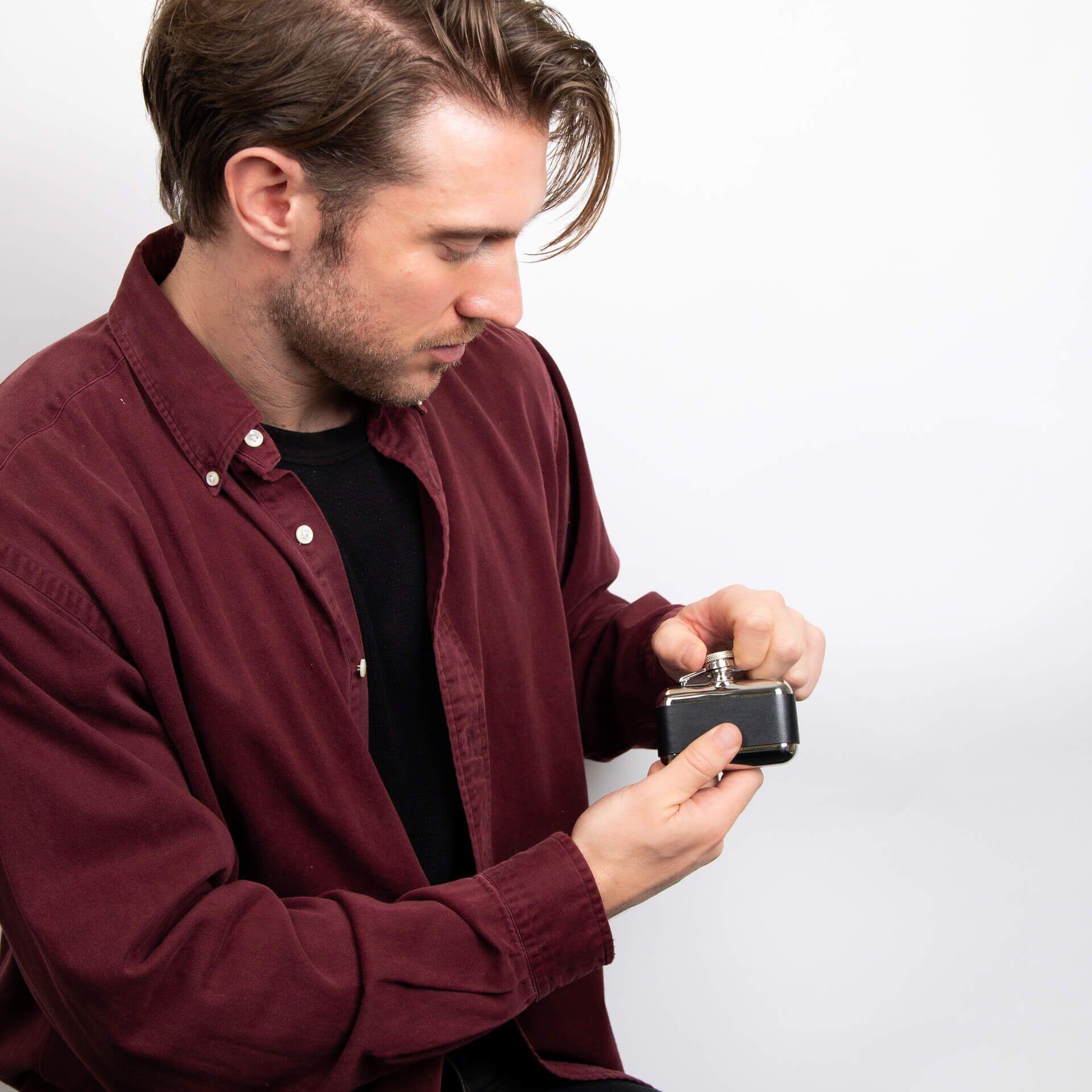"fredbennett® 3oz Stainless Steel and Black Leather Hip Flask – a rugged, compact flask with free engraving on the leather wrap. The perfect personalised gift for nature lovers, best men, or Father’s Day. Available at Gold and Diamonds."