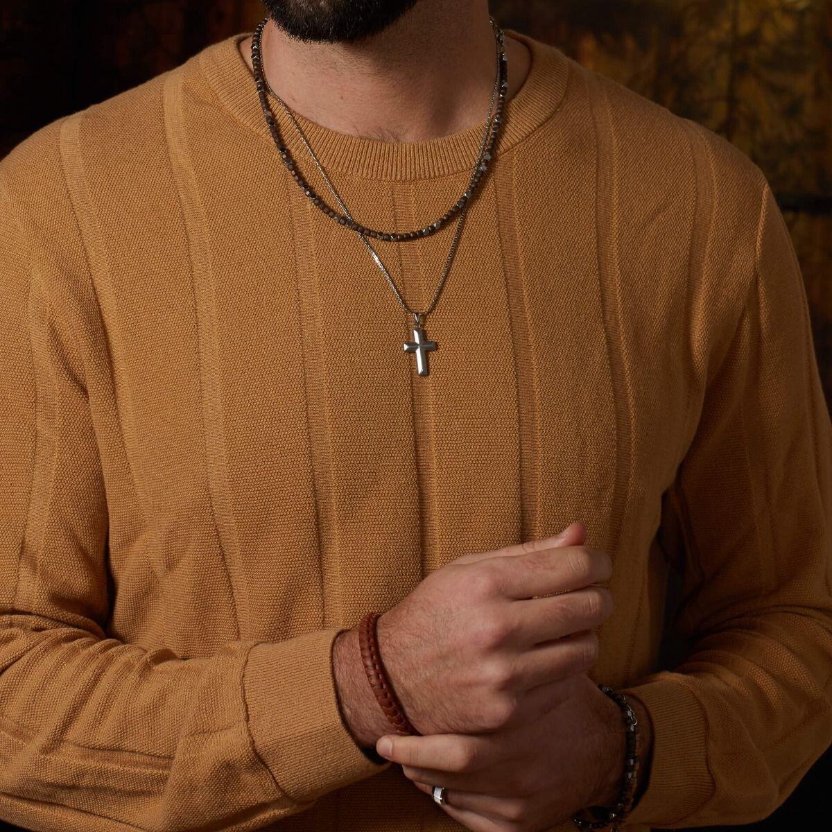 "fredbennett® Damascus Steel Cross Pendant with stainless steel chain – featuring rippling grain texture and bold structure. Hypoallergenic and presented in a suede pouch from Gold and Diamonds."