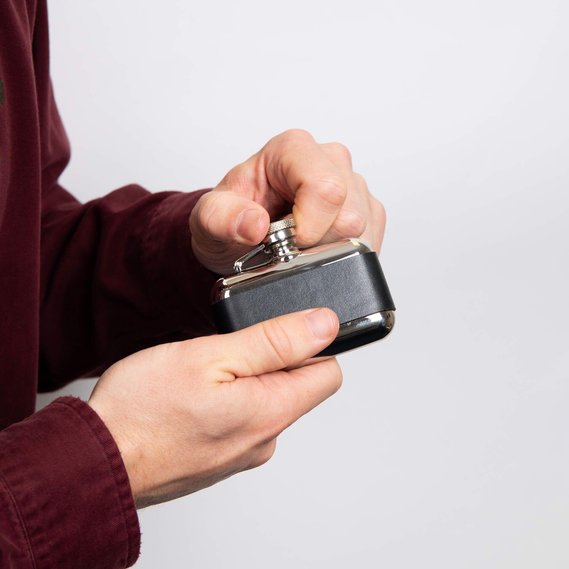 "fredbennett® 3oz Stainless Steel and Black Leather Hip Flask – a rugged, compact flask with free engraving on the leather wrap. The perfect personalised gift for nature lovers, best men, or Father’s Day. Available at Gold and Diamonds."
