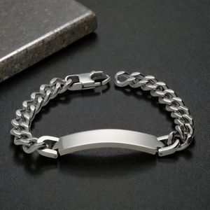 Men's engraved silver stainless steel ID bracelet on stone tile background