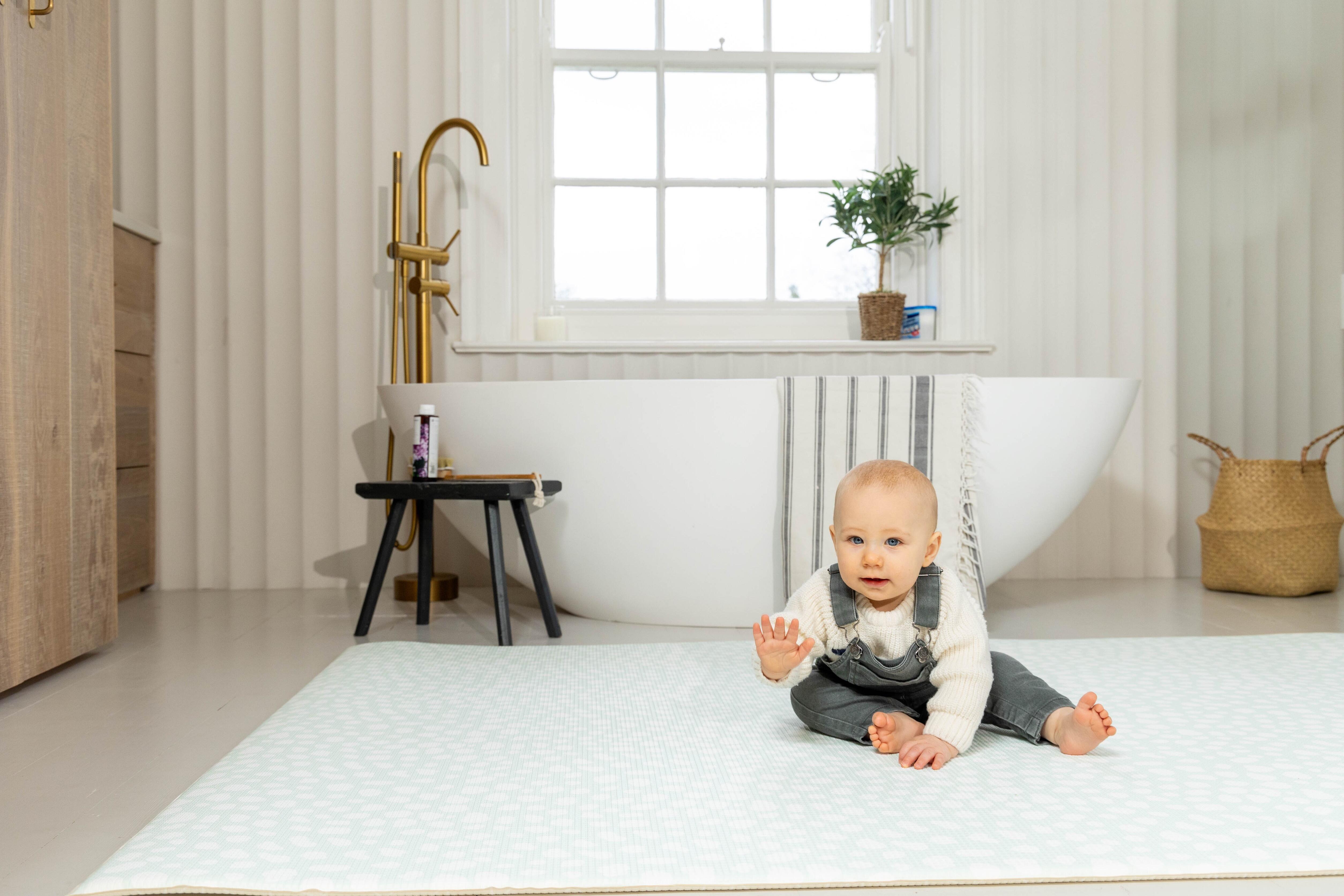 Baby lying on Soft Mint Darling Dalmatian playmat – wipe-clean non-toxic foam design for neutral nurseries