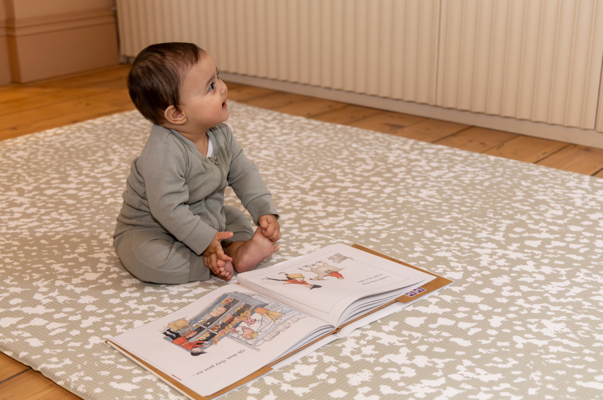 Baby Sitting on Speckled Kisses Playmat in Olive